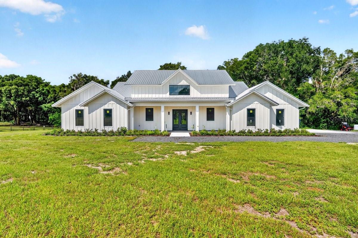 LUXURY NEW CONSTRUCTION ON 2.5 ACRES: JUST COMPLETED & MOVE-IN READY!
Property features virtually staged furniture for illustrative purposes.

Escape to your private oasis in highly-desirable DeLand! This brand-new, custom-built estate—completed July 6, 2026—offers the rare combination of private country living on 2.5 ACRES with the convenience of being just minutes from Historic Downtown, Stetson University, and top-rated schools.

This spectacular 4-bedroom, 3.5-bath residence boasts 3,333 sq. ft. of living space (4,965 sq. ft. total under roof). Designed for modern luxury, the home features tranquil, private water views across your own slice of paradise, offering a serene backdrop to your daily life. Enjoy the rare benefit of full ownership of your waterfront, allowing you to enjoy peaceful mornings or golden-hour sunsets from the comfort of your own backyard.

The massive, open-concept layout is dramatically enhanced by STUNNING VAULTED CEILINGS throughout the main living area, creating an incredible sense of light and scale. The gourmet kitchen is a chef's dream, featuring a truly grand center island, two sinks, a dedicated beverage center, and a light-filled walk-in pantry with a scenic view of the property. The kitchen flows seamlessly into the immense dining and entertainment area, which showcases a stunning 12-foot built-in bar.

The home offers exceptional sleeping arrangements, including a Luxurious Primary Suite with its own VAULTED CEILING and a spa-like bathroom with double vanity and an impressive double shower. A perfectly integrated walk-in closet connects directly to the laundry room for unmatched convenience. Guests will enjoy the Spacious Junior Suite with its own walk-in closet and beautiful attached full bathroom, alongside two additional large guest rooms that share a well-appointed guest bathroom.

Florida living is optimized with EXPANSIVE PORCH AREAS that provide plenty of space for outdoor dining, lounging, and taking in those beautiful water views. Functionality is paramount, with a dedicated front-of-house office space for quiet work, and a utility wing featuring a large mudroom and coat closet leading to an extended 2-car garage.

Tucked away on a quiet road, enjoy only the sounds of nature, yet maintain quick access to all local amenities. With No HOA or deed restrictions, you have the freedom to bring your boat, RV, or dreams! This is the best of both worlds—private, brand-new, and ready for you to call home.

Schedule your private tour today to experience this stunning new estate firsthand!