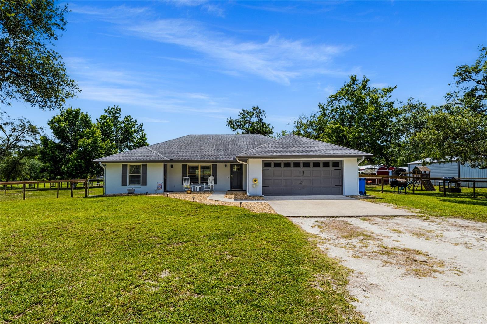 Rare opportunity to own a highly versatile 6-acre AG-exempt estate in sought after Lake Helen. This exceptional property features a beautifully maintained pool home, separate barndominium, multiple insulated and powered outbuildings, RV accommodations, equestrian amenities, and extensive space for agricultural pursuits, hobbies, equipment storage, or a home-based business.  The main residence offers 3 bedrooms, 2 baths, and approximately 1526 square feet of living space with an attached 2 car garage.  Recent updates (2022) include remodeled kitchen featuring an island, an updated primary suite with double sinks and dual walk-in closets, indoor laundry, and luxury vinyl flooring throughout the main living areas with carpet in the bedrooms. Designed for privacy, functionality, and country living, this unique property offers endless possibilities.

The main residence is complimented by a stunning screened saltwater pool completed in 2023, featuring a sun shelf, built-in bar seating, and spacious outdoor living areas. A fenced backyard with electric dig deterrent fencing, gated entry, keypad access, motion lighting, and numerous upgrades create a private and welcoming retreat.

The separate barndominium offers comfortable living space along with 2 bedrooms, 2 baths, full kitchen with living room/ dining room area with an oversized insulated garage, wraparound covered porches, RV hookup and pad, fenced dog yard with electric dig deterrent fencing, 10-foot ceilings, multiple roll-up doors, and its own septic system installed in 2023. The flexible design makes it ideal for guests, extended family, hobbies, or live-work opportunities.

Multiple insulated and powered outbuildings provide exceptional flexibility for workshop space, equipment storage, agricultural operations, woodworking, automotive projects, crafts, trades, or a home-based business. One building includes office space, air conditioning, windows, and a full bath. The workshop and office complex enjoys its own separate gated entrance, providing convenient access for equipment, trailers, deliveries, or business operations. Additional features include separate metering, ample parking, and a circular asphalt-milled drive.

Equestrian enthusiasts will appreciate three fenced pastures, livestock accommodations, tack/feed facilities, chicken coop, and pole-barn shelters. The property also features separate gate from the side road with an alleyway between the pastures for added security and convenience off loading livestock.

Located in Lake Helen, a golf-cart-friendly community known for its equestrian heritage and small-town charm, this property offers a lifestyle rarely found in Central Florida.

Whether you’re seeking a private family compound, equestrian estate, agricultural retreat, hobby farm, or a property with extensive workshop and storage capabilities, this exceptional estate delivers a rare combination of comfort, flexibility, and country charm.
