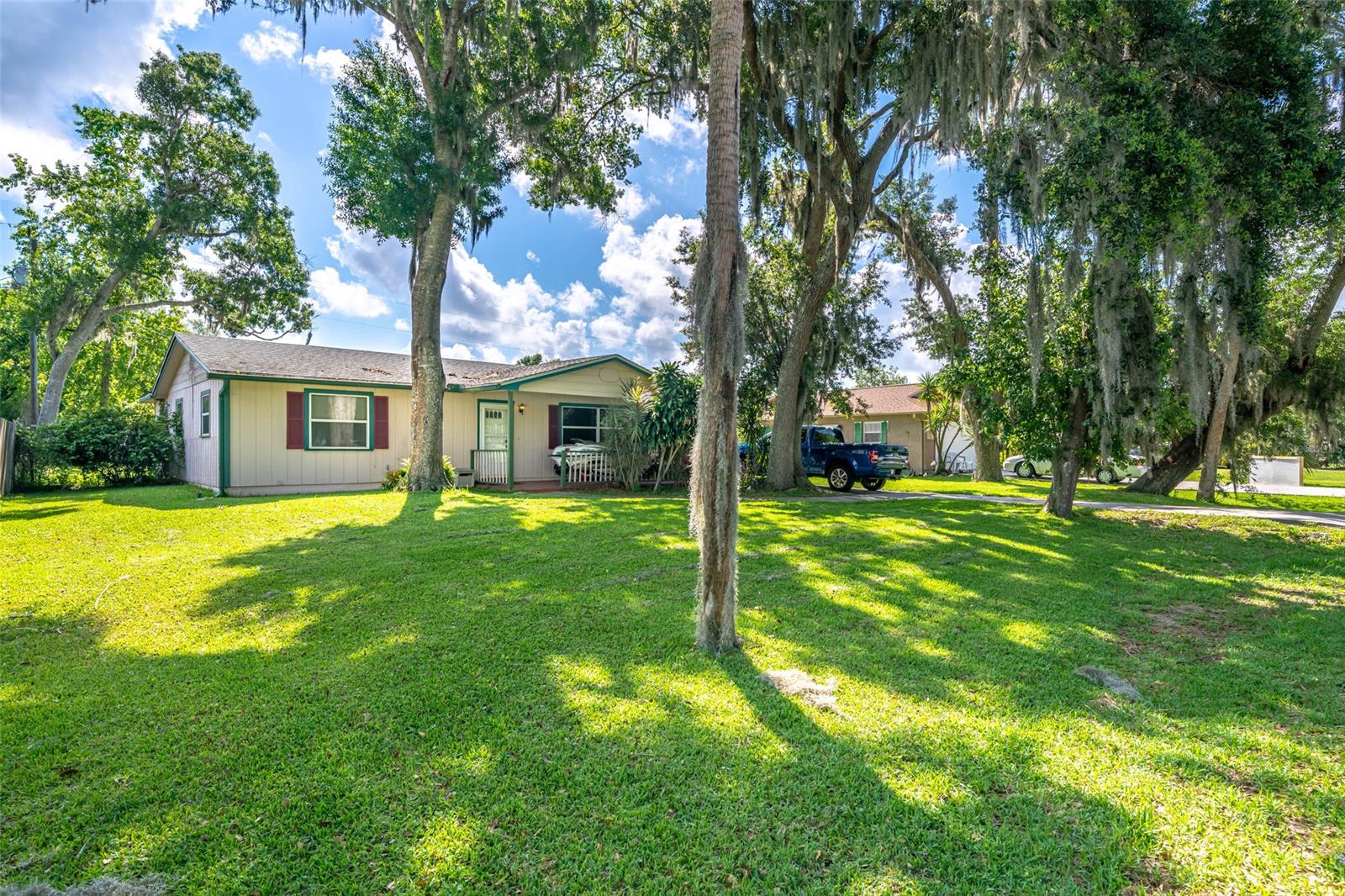 2 bedroom, 2 bath, single car garage nestled under large oak trees in the heart of Florida Shores. This home features an open floor plan, large wood-burning STONE fireplace. Carpet throughout living room and bedrooms. Guest bathroom has tile flooring, single vanity and tub/shower. Vinyl flooring through kitchen/dining area (kitchen could use a little updating.) Walk out of kitchen into enclosed Florida room. This home also features a large fully FENCED back yard, fully equipped for your fur baby. NEW roof and NEW central A/C within past 5 years. CASH or CONVENTIONAL offers only. ;Water: City