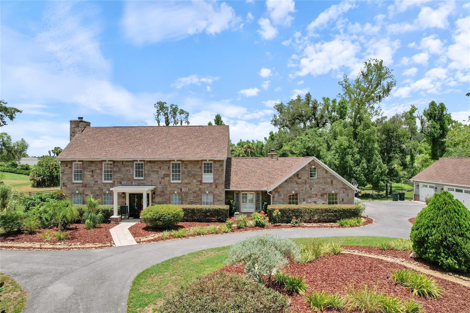 Welcome to timeless elegance and exceptional craftsmanship in this stunning custom estate. From the moment you step through the grand entry, you'll be captivated by rich cherry hardwood floors, exquisite marble tile, intricate crown molding, and refined architectural details that reflect enduring quality and classic design.
The formal living room showcases elegant wainscoting, decorative wall niches, encased windows, and a wet bar complete with a beverage refrigerator and sink—perfect for entertaining. The gourmet kitchen is a chef's dream, featuring custom cherry cabinetry, distinctive granite countertops, a large center island with prep sink, travertine backsplash, double sinks, a Thermador six-burner gas range with griddle, and a convenient pot filler. A sunny breakfast nook overlooks the expansive, private backyard.
Host memorable gatherings in the spacious formal dining room with ample space for a china cabinet or buffet. The guest bath offers direct access to the lanai, making outdoor entertaining effortless.
A charming library or reading room with a cozy fireplace and surround windows provides a peaceful retreat while overlooking the front grounds and offering access to the lanai. The impressive family/game/media room features a stunning custom built-in entertainment center with granite accents, and generous space for a pool table or additional seating.
Just off the media room is a private in-law or guest suite, offering exceptional flexibility for multigenerational living, extended guests, or a private retreat. This spacious bedroom includes an enormous walk-in closet with abundant storage and is tucked away for added privacy. 
Step outside to the covered, screened lanai, ideal for relaxing or entertaining while overlooking the expansive concrete patio with plenty of room for grilling, outdoor lounging, or adding a hot tub.
The grand staircase leads to two spacious guest bedrooms, a convenient laundry room, and an exceptional primary suite featuring an updated spa-inspired bath and an oversized walk-in closet.
Additional highlights include a detached garage with mezzanine storage, abundant custom millwork throughout, and quality finishes at every turn. Offering privacy, generous living spaces, and a highly desirable location close to everyday conveniences, this remarkable home delivers the perfect blend of luxury, comfort, and timeless appeal.
Furnishings are available separately.