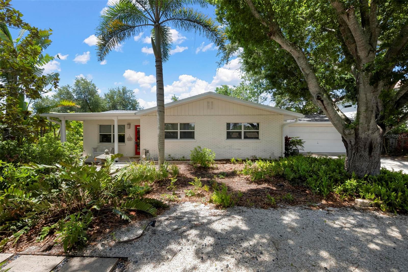 Nestled on a private, generously sized lot on the north end of the Island is a 3 bedroom, 3 bath home with over 2100 sq ft living area.  Enter into this 1960's era with terrazzo floors, built ins and then onto a large addition in 2002 which blends timeless original character with some updates. Offering an expansive split-bedroom floor plan, the residence provides both comfort and privacy with flexible spaces designed for everyday living and entertaining.  The kitchen has wood cabinets, a pot filler faucet by the stove and a unique walk-in pantry.  The dining room and the primary bedroom both have aquarium windows.  The large fenced yard needs your loving care to make it your own private paradise. There is a well for irrigation, hurricane panels for windows and the roof is about 5 yrs old. A breezeway connects the home to a 2-car garage. Shade trees adorn the front.  You cannot go wrong with this home with its vintage character, spacious layout, mature setting and secluded feel.  This property offers a rare opportunity to enjoy the best of both old Florida charm and modern convenience.  Whether you want this blended design home or build exactly what you want, you will love this location, close to the beach and the shops down town.  Island life also offers dining, live theater, library, art center, and more in this bike friendly town.