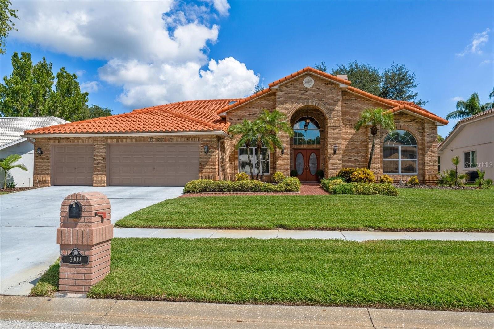 Rarely available in THE RESERVE AT LAKE TARPON, an EXCLUSIVE ENCLAVE of just 52 homes, this Maconi custom-built residence offers a rare combination of LUXURY and TIMELESS DESIGN. Set on a PREMIUM LOT with DISTANT VIEWS OF LAKE TARPON, this meticulously maintained one-owner home has been thoughtfully cared for and BEAUTIFULLY PRESERVED.  The home's stately brick façade, covered front porch, and mature landscaping create an unforgettable first impression. Inside, a grand marble foyer opens to SOARING CATHEDRAL and VAULTED CEILINGS reaching approximately 14.4 feet - an ARCHITECTURAL FEATURE rarely found in today’s homes that enhances scale, natural light, and openness throughout the main living areas. Encompassing 2,684 square feet, the thoughtfully designed floor plan offers 4 bedrooms, 3 full baths, an oversized 3-car garage, and a desirable split-bedroom layout that balances everyday comfort with exceptional spaces for entertainment. The grand foyer welcomes you with marble flooring, abundant natural light, and expansive living areas. The family room serves as the centerpiece of the home, highlighted by a marble-surround wood-burning fireplace, volume ceilings, and sliding glass doors opening to the outdoor living space. Formal living and dining rooms provide elegant gathering areas, while the EUROPEAN-INSPIRED KITCHEN rich in character, showcases distinctive black-and-white tile accents, generous cabinet storage, a functional peninsula, pantry, skylight, breakfast nook, and seamless access to the lanai. The primary suite serves as a relaxing retreat, featuring sliding glass doors opening directly to the pool lanai and a spacious ensuite bath with marble flooring, soaking tub, dual vanities, walk-in shower, and an oversized walk-in closet. Two secondary bedrooms and a full bath are in a separate wing of the home, which can be privately closed off from the main living areas by a pocket door—an ideal feature for family and guests. The fourth bedroom, complete with its own full bath and direct pool access, is ideally suited as a guest suite, in-law suite, home office, or flexible living space. Outdoor living is equally impressive with an oversized 15' x 30' screened pool, covered lanai, paver deck, and dedicated 10’ x 6’ pool storage closet. Sliding glass doors from the living room, kitchen, primary suite, and fourth bedroom open directly to the pool area, creating a seamless indoor-outdoor flow ideal for Florida living year-round. Additional highlights include a tile roof (2012), A/C (2015), hot water heater (2020), exterior paint (2024), and a new pool pump (2026), along with underground utilities, sidewalks, and streetlights. The property is NOT IN A FLOOD ZONE so (no flood insurance required), offering added peace of mind.  Begin each day with scenic walks near Lake Tarpon, surrounded by the PRIVACY and TRANQUILITY of this exclusive, tucked-away community.  Ideally located near Innisbrook Golf Resort and local parks, the home offers convenient access to recreation, dining, and everyday amenities. Zoned for TOP-RATED SCHOOLS, this highly desirable location combines privacy, convenience, and long-term appeal, completing a rare offering within one of North Pinellas County's most sought-after communities.