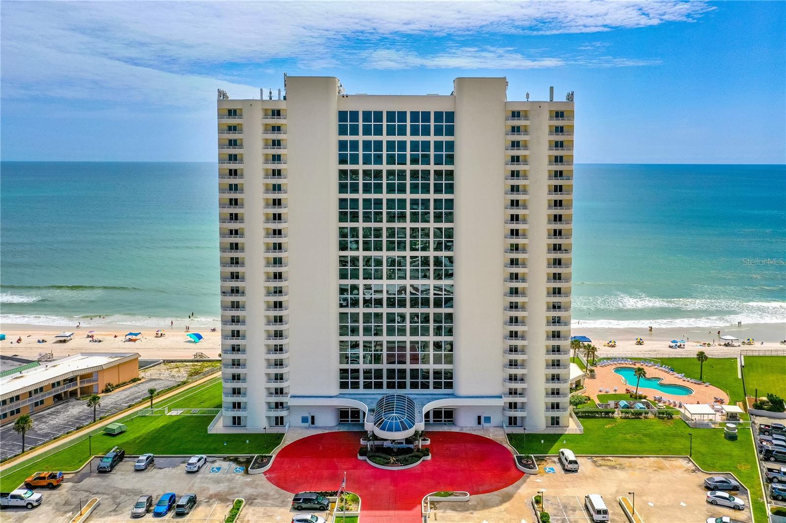 Discover the ultimate in oceanfront sophistication at The Peninsula Condominium, Daytona Beach Shores' most celebrated address—honored as the premier condominium building in the area for 2022, 2023, 2024 and 2025. This stunning, fully furnished two-bedroom, two-bathroom first-floor residence offers unobstructed, jaw-dropping Atlantic Ocean views straight from the primary suite and expansive living spaces, enhanced by peace-of-mind hurricane-impact windows and sliding doors throughout.

Inside, an airy, open-concept layout seamlessly blends living and dining areas, featuring a handy breakfast bar, a fully equipped kitchen with ample pantry storage, and the convenience of in-unit laundry. From the living room, glass sliders lead directly to a generous private patio overlooking a lush, expansive green lawn—your personal seaside oasis perfect for savoring morning coffee or unwinding with spectacular sunsets, with the beach just steps away.

Resort-style living awaits with The Peninsula's exceptional amenities: a breathtaking 23-story atrium lobby featuring an indoor river and cascading waterfall, a panoramic penthouse club room with sweeping coastal views, an indoor heated pool, a sparkling outdoor pool, a relaxing heated spa, poolside grilling areas, a state-of-the-art fitness center, billiards and ping-pong tables, a serene library, and a card room for social gatherings.

With all assessments paid, strong reserves, and recent building restorations complete, this community is in outstanding financial and physical condition. Ideally located just minutes from top shopping, dining, and the vibrant Daytona Beach Shores scene, this home embodies refined coastal living at its finest.

Rare opportunities like this don't last - schedule your private tour today and claim your slice of oceanfront paradise! Price is firm. All furnishings to stay.