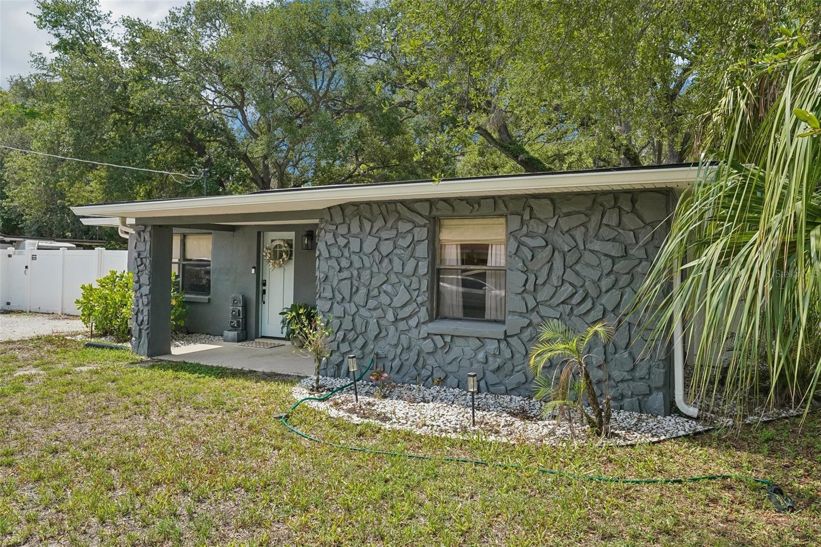 Welcome to this beautifully updated block home in the highly sought-after Ballast Point neighborhood of South Tampa, where million-dollar homes are being built just steps away, making this an exceptional opportunity in a rapidly growing area. Situated on an oversized 0.20-acre  lot with mature trees, this move-in-ready 3-bedroom, 1-bath residence features a spacious driveway with plenty of parking and blends modern updates with timeless charm. Inside, you'll find brand-new luxury vinyl plank flooring throughout, a completely remodeled bathroom with a stunning walk-in tiled shower, and a custom-built media wall with an electric fireplace that creates the perfect focal point in the living room. The beautifully updated kitchen is equipped with quartz countertops, stainless steel appliances, ample cabinetry, and a built-in pantry, offering both style and functionality. Step outside to a fully fenced backyard with endless possibilities for entertaining, gardening, or adding a pool, along with a detached air-conditioned bedroom ideal for a home office, guest room, gym studio, or hobby room, plus an additional storage shed for extra storage. Conveniently located just blocks from Bayshore Boulevard, Ballast Point Park, MacDill Air Force Base, downtown Tampa, shopping, dining, and entertainment, this home offers the perfect combination of location, updates, and future investment potential. Don't miss your chance to own a beautifully updated home in one of South Tampa's most desirable and rapidly appreciating neighborhoods. Book your showing today!!!