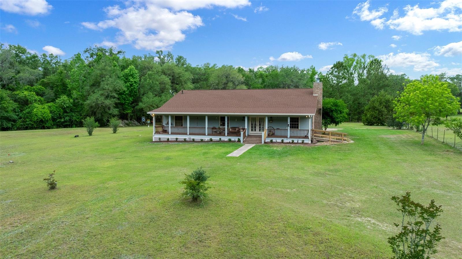 Welcome to your private North Florida paradise at 732 SW Carl Wilson Road, Fort White, FL — a rare opportunity to own a fully equipped 25.5-acre estate designed for country living, equestrian use, outdoor recreation, and self-sufficient living in the heart of Columbia County. This stunning 3-bedroom, 2-bathroom custom home combines modern upgrades, oversized living spaces, and unmatched outdoor amenities just minutes from some of Florida’s most beautiful natural springs and rivers.

Situated on a county-maintained road, this gated and fully fenced property offers peace of mind, privacy, and functionality from the moment you arrive. The home features oversized bedrooms, including spacious secondary bedrooms, and large handicap-accessible bathrooms, creating comfort and convenience throughout. Major updates include a new roof (2025), HVAC system (2024), water heater (2024), updated electrical boxes, and all-new electrical wiring for the transfer box, ensuring the property is move-in ready and built for long-term reliability.

Prepared for true country independence, the estate includes a full-house and property generator installed in 2021, powered by propane with two propane tanks that are owned outright. The property also features solar-powered gated entry, adding both security and efficiency. With one well and two pumps, the infrastructure is substantial enough to support the existing home, barn, and even a future second residence if desired.

Outdoor enthusiasts and equestrian buyers will appreciate the impressive amenities, including a 5-stall barn with tack room, fully fenced property with one large paddock (that can easily be divided) with an automatic watering system, and a separate 4-car garage offering ample space for vehicles, ATVs, boats, tractors, or workshop needs. The property also includes two RV hookups — one conveniently located near the main home and another beside the separate screened-in lanai, perfect for guests, RV travelers, or multi-generational living.

Nature lovers will fall in love with the scenic fish-stocked pond complete with a private island, abundant wildlife including deer and turkey, and a wooded section thoughtfully set up for target shooting and outdoor recreation. Relax by the above-ground pool featuring a new pool heater installed in 2025, or enjoy the vineyard and greenhouse that add charm and endless possibilities for hobby farming or sustainable living.

Located in desirable Fort White, Florida, this property offers easy access to some of Florida’s most sought-after outdoor destinations, including Ichetucknee Springs State Park, Ginnie Springs, Santa Fe River, and countless opportunities for kayaking, tubing, boating, fishing, hiking, horseback riding, and diving in crystal-clear springs. Fort White is known for its peaceful rural atmosphere while still being conveniently located near Lake City, High Springs, Gainesville, and major North Florida travel routes.

Whether you’re searching for a horse property, private ranch, multi-use homestead, hunting retreat, family compound, or simply a luxurious slice of Old Florida living, this exceptional estate offers unmatched versatility, privacy, and value. Don’t miss your chance to own one of Fort White’s most unique and fully equipped acreage properties.