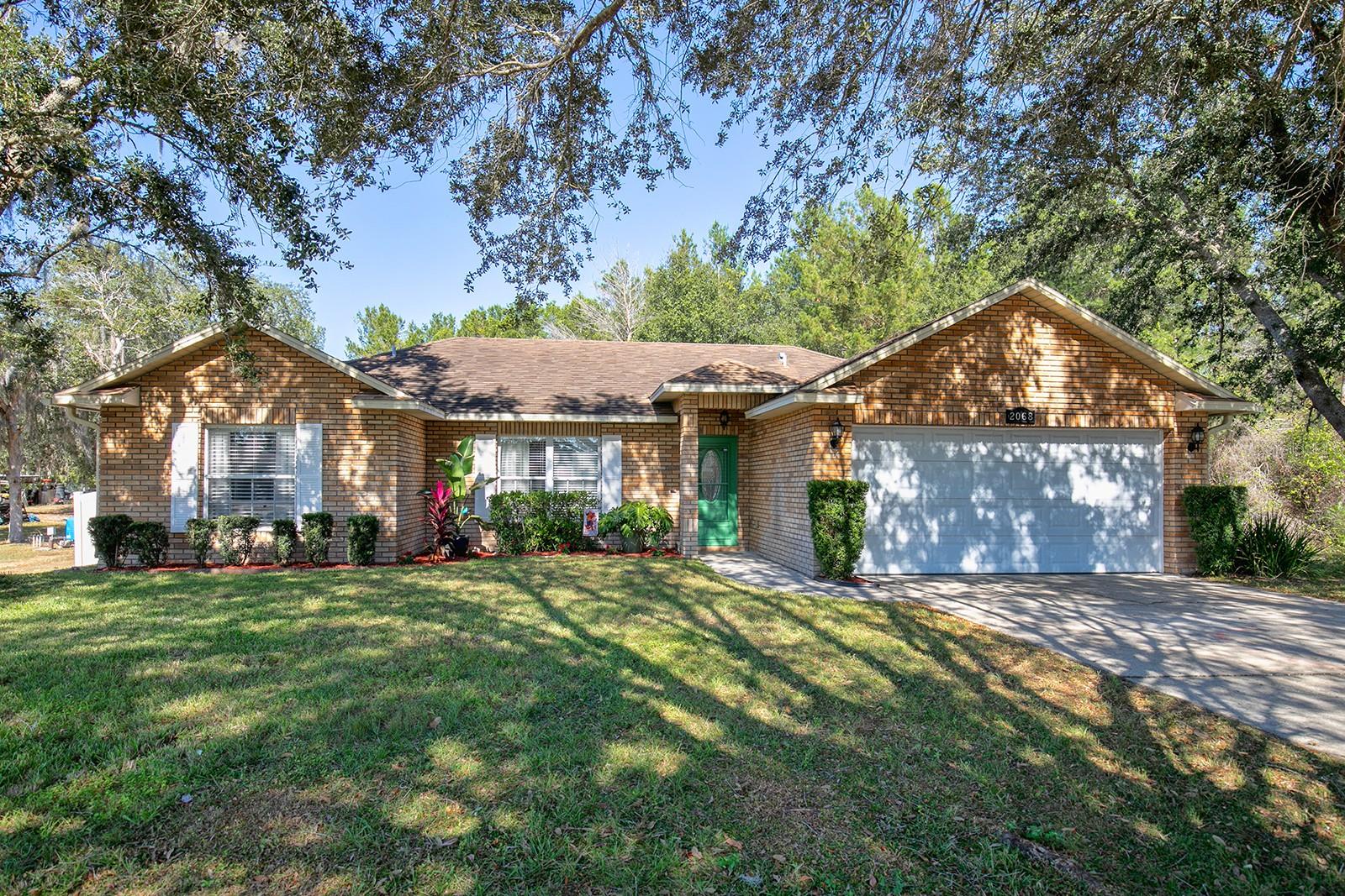 Gorgeous, updated, move in ready 3 bedroom, 2 bath, 2 car garage home is waiting for your family!  This open concept home has volume ceilings, decorator ledges, NO CARPET, NO HOA, new luxury vinyl and tile flooring, new sliding glass door with blinds inside the double panes,  stainless steel appliances, granite counters, a designer backsplash, and interior laundry room that comes with the washer and dryer. The large primary bedroom has a brand new en suite bathroom with a luxury jetted tub to relax in after a long day. So many attributes and lots of storage in this home! Enjoy the huge front yard and huge back fenced yard.  No rear or side neighbors for maximum privacy.  Walk and bike to the trails. Minutes away from Publix, Lowes, a wonderful bakery, and cool eateries.