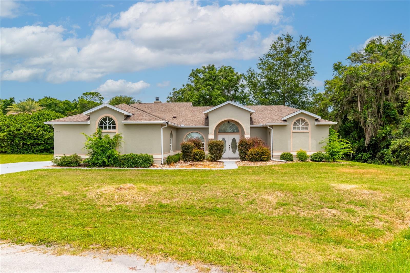 Bright and spacious pool home situated on a rare 0.75-acre lot in a quiet cul-de-sac setting. This well-maintained residence features soaring ceilings, skylights, and an abundance of natural light throughout. Recent updates include new appliances, new A/C, and new flooring in the kitchen and primary bedroom. Enjoy Florida living with a screened pool and spa, dedicated pool bath, outdoor shower, and an entertaining bar area. Additional highlights include a fireplace, two-car garage, generous living spaces, and a peaceful location within the community. A unique opportunity to own a private oversized homesite with plenty of room to relax and enjoy the outdoors.