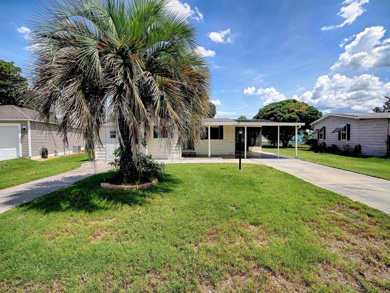 Located in the original heart of The Villages—a vibrant, 55-plus community where endless activities, world-class amenities, and a lively social calendar define everyday life—this well-rounded, move-in-ready residence offers the perfect blend of comfort, convenience, and affordability. Set on a generous homesite, the property welcomes you with a spacious carport and a separate storage room that doubles as a golf-cart garage, while a dedicated laundry room just off the carport adds practicality to daily routines.

Come inside and discover an open, light-filled floor plan adorned with luxury-vinyl-plank flooring that flows through the main living spaces, creating a seamless, low-maintenance backdrop for both relaxed family evenings and lively gatherings. The living room boasts elegant chair-rail molding and soaring vaulted ceilings that amplify the sense of space, while large windows invite the natural beauty of The Villages’ meticulously landscaped streets to drift indoors.

The kitchen has been thoughtfully updated to meet modern tastes: a bright solar tube bathes the space in daylight, brand-new cabinets provide ample storage, and sleek stone countertops create a stylish surface for meal preparation and entertaining. Adjacent to the kitchen, a side-enclosed lanai extends the living area outdoors, featuring the same luxury-vinyl-plank flooring and offering a tranquil spot to enjoy morning coffee or sunset views of the expansive backyard.

Both bedrooms are finished with warm laminate flooring, providing a comfortable, carpet-free environment that’s easy to keep pristine. The primary bathroom has been refreshed with a contemporary vanity and a new shower unit, delivering a retreat after a day of golfing, pickleball, or exploring the community’s countless clubs and events.  

Beyond the home itself, The Villages provides an unrivaled lifestyle: championship golf courses, sparkling pools, state-of-the-art fitness centers, endless social clubs, arts and crafts studios, dining venues, and top-tier medical facilities—all just minutes from your front door. With a new roof installed in 2025, the property is ready for you to personalize and call home, offering a perfect canvas for anyone seeking a dynamic, active retirement or an investment in a community that truly has something for everyone.