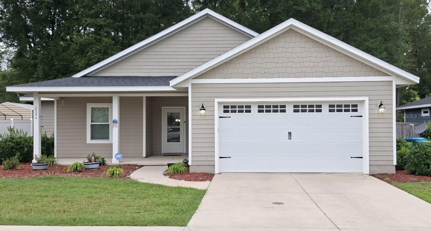 This lovely home is located quiet back street in Spanish Gates, High Springs. Convenient to schools and shopping, this beautifully maintained home is in spotless condition. Smart layout, open design, luxury vinyl flooring, carpeted bedrooms, beautiful kitchen with solid granite counter tops. Washer, stove, microwave stove and refrigerator are  2025 or newer. Screened Back porch, Wood privacy fence, expansive woods behind for quiet outdoor enjoyment. Wireless Irrigation, thermostat and door camera, upgraded garage door opener are just a few of the amenities that make this home a special place for quiet and enjoyable living. Come and make it yours!