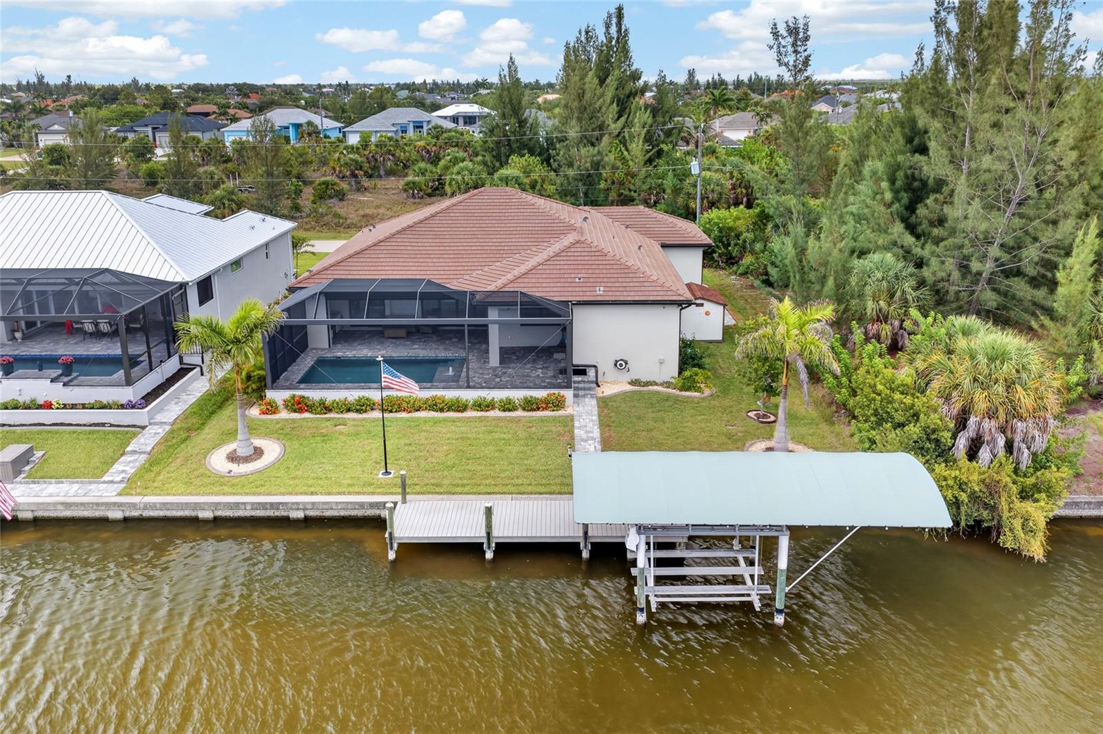LUXURY WATERFRONT LIVING MEETS THOUGHTFULLY CRAFTED DESIGN. Built in 2023 with no detail overlooked, this EXCEPTIONAL custom waterfront residence delivers the perfect blend of luxury, functionality, and Florida lifestyle on a seawall canal lot complete with a private dock, boat lift, and resort-style outdoor living.

Offering 3 bedrooms, 3 full bathrooms, a 3-car garage, and 2,261 square feet of beautifully designed living space, this home immediately impresses with soaring 9'4" ceilings, elegant tray ceilings with crown molding, wood-look ceramic tile flooring throughout, plantation shutters, and an architect-designed feature wall with an included 85" Sony television. Hurricane impact windows and doors, spray foam insulation, a premium flat tile roof, and six-course stem wall construction provide EXCEPTIONAL quality and peace of mind.

At the heart of the home is a STUNNING chef's kitchen featuring upgraded Oxford Legacy soft-close cabinetry, a massive 10-foot Calacatta quartz island, quartz countertops, a beveled tile backsplash, under-cabinet lighting, GE Profile appliances (including a double wall oven with convection microwave), radiant cooktop, canopy range hood, Delta touchless faucet, and reverse osmosis water filtration system.

The LUXURIOUS primary suite offers a tray ceiling with crown molding and a spa-inspired ensuite featuring a walk-in shower with rainfall shower head, handheld wand, dual quartz shower benches, floor-to-ceiling tile, quartz countertops, and premium finishes throughout.

Designed for EFFORTLESS indoor-outdoor living, the EXPANSIVE covered lanai showcases tongue-and-groove wood ceilings, and a fully equipped outdoor kitchen complete with granite countertops, an illuminated NXR grill, vent hood, Bull refrigerator, and a mounted 50" LG television. The PebbleTec SALTWATER pool is a true backyard retreat with a sun shelf, bubbler, LED lighting, wireless controls, variable-speed pump, and Gulfstream heater for year-round enjoyment.

Boating enthusiasts will appreciate the PRIVATE 8'x30' DOCK featuring electric and water service, a 7,000-pound Dolphin Hybrid boat lift with remote, lighted canopy, and LED dock lighting, perfectly set up for a tritoon or your next day on the water.

Additional highlights include an oversized epoxy-finished 3-car garage with insulated doors, overhead storage, a 30-amp outlet, custom Tuff Shed, professionally landscaped grounds with decorative curbing and irrigation, SimpliSafe security system with exterior cameras, remote-operated storm shutters, spacious laundry room complete with built-in upper cabinetry and a deep utility sink, and countless custom upgrades throughout.

Adding even more value, the county-owned property across the street helps preserve your view with no future residential development anticipated. This is a rare opportunity to own a truly EXCEPTIONAL waterfront home where every detail has already been thoughtfully completed.
