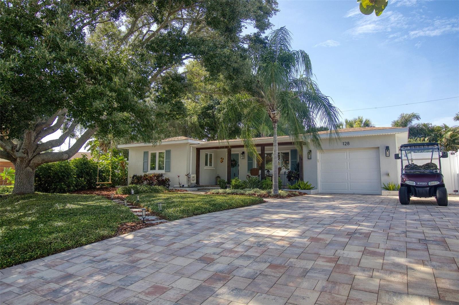 This tres chic 2 bedroom, 1.5 bath super cute Mid Century stunner sits gracefully on a beautifully landscaped lot, NOT A FLOOD ZONE in the desirable Edgewater Terrace neighborhood a mere 350 ft from Edgewater Drive and St Joseph Sound.  You will fall in love with this pristine home because of it's beauty and style with the added bonus of being in the delightful Dunedin golf cart area. Jump into your golf cart and venture downtown for dinner, or one of the many festivals or farmers markets. This charming home is tastefully renovated and boasts a spacious living room, 2 generous sized bedrooms and a spacious kitchen with exquisite quartz countertops, 42" soft close white cabinetry, newer stainless steel appliances and coastal blue tile backsplash.  The primary bedroom is a light and bright retreat and is located at the front of the home. Bedroom 2 is also spacious and located at the rear of the home.  The bathroom has been professionally designed and renovated in 2023 capitalizing on beauty and functionality. The light and bright 180 sq ft Florida room is not included in the home's square footage and leads to the spacious Oasis backyard creating a seamless blend of indoor/outdoor entertainment living. The backyard is awesome!  It is so beautiful outside with many native flowers and plants that attract birds and butterflies and is fenced for privacy.  The jewel of this magnificent backyard is a new heated above ground spa, an outdoor shower and a fire pit for enjoying the outdoors. There is also a large shed for storage. The outdoors has extensive outdoor lighting and is stunning after dark.  The lighting and irrigation system were installed in 2025. This home is move in ready with tasteful touches such as; neutral color tones, modern light fixtures, Plantation shutters, Thermal Block out blinds, 12x24 grey floor tiles in the kitchen and engineered hardwood floors throughout this impeccably clean and welcoming home. This home also features newer rain gutters, hurricane impact windows in primary bedroom(2021) and newer double pane windows, a/c (2015), a newer tankless gas hot water heater (2021) and extensive paved driveway and pathway (2021). There is plenty of natural light and room to grow in this well laid out open floor plan. Couple this with excellent schools and walk or golf cart to restaurants, cafes, shops, the iconic Fenway Hotel, airports, beaches and all that fabulous downtown Dunedin has to offer and you have the quintessential Florida lifestyle home.