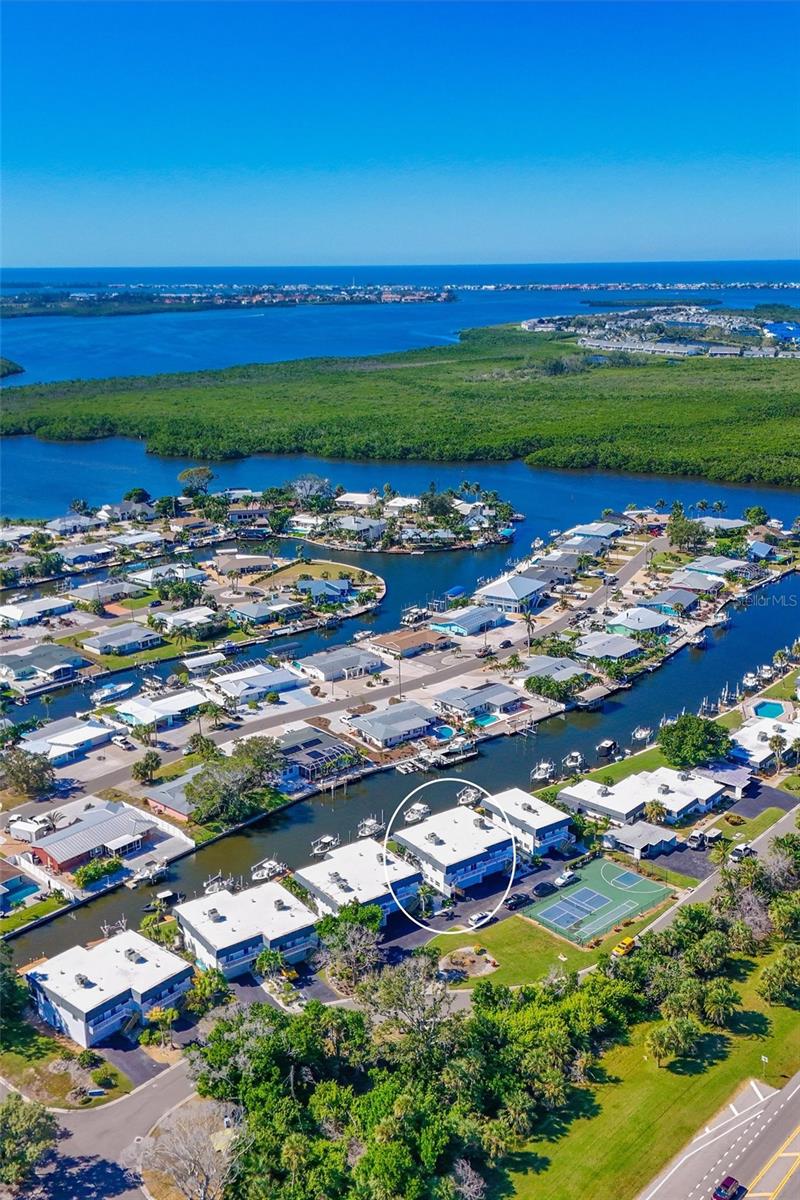 Attention Fishing, Boater and Beach Enthusiasts - Don't Let this Property Get Away!!!  Waterfront Condo with 10,000# Boat Lift and Dock in your backyard! Location is paramount when it comes to Florida outdoor living. This exceptional waterfront two-story condominium, with 1,728 sq. ft. under air, 2 bedrooms, 3 baths, 2 bonus rooms, family, dining and living rooms, inside laundry closet and a 2-car oversized garage.  The dock is equipped with water and electricity. The property offers direct access to Palma Sola Bay, the Intercoastal Waterway, Egmont Key, and Gulf—all minutes away—with no fixed bridges impeding navigation. Surrounded by saltwater canals, the area provides excellent opportunities for kayaking and canoeing. Nature enthusiasts will appreciate the proximity to Neal Preserve and the sandy white beaches of Anna Maria Island (AMI), located just three miles from the property. The home emphasizes maintenance-free living, presenting numerous options to enjoy the surroundings both day and night. Manatees and dolphins are frequently observed in the saltwater canal directly in front of the screened-in porches, while the sunsets create a stunning backdrop. Upon entry, shiny bamboo flooring leads you down the hallway. The well-appointed chef’s kitchen includes stainless steel appliances, an induction stove and air fryer, solid wood cabinetry, under-cabinet lighting, and expansive granite countertops. The guest bedroom and updated guest bathroom are situated to the left, with the primary bedroom offering canal views. The living and dining rooms are located straight ahead, with easy access to the downstairs area via the adjacent staircase. Impact sliding doors lead out to screened-in porches on both levels. The first-floor features durable tile flooring, storage under the stair well, Endura flood waterproof drywall, a comfortable family room, a full bathroom, and two versatile bonus rooms currently utilized as guest bedrooms. Community amenities include an oversized heated pool, tennis/pickleball court, and a basketball court. In addition, shopping, restaurants, entertainment venues, downtown Bradenton, Sarasota, Longboat Key, St. Armands, UTC Mall, and Sarasota/Bradenton Airport are all conveniently nearby. Florida Living, Sunshine, and NO State Income Tax! Possible temporary 1-0 buydown rate covered by lender. Call for details. Schedule your private showing now!