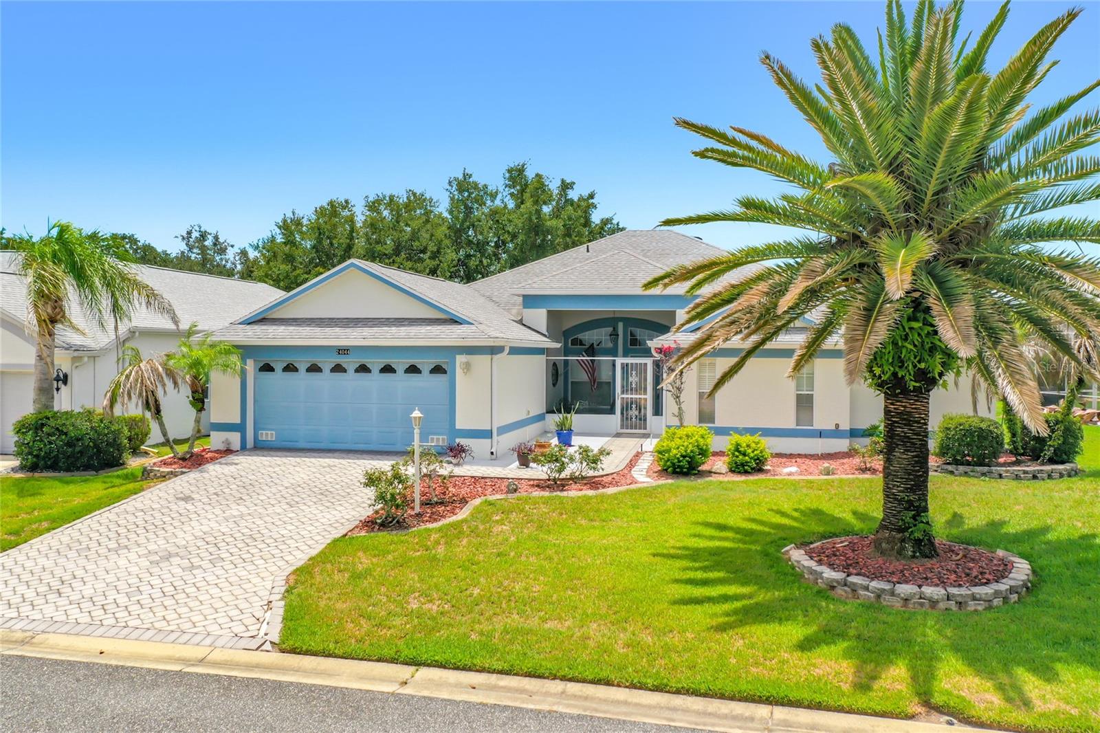 Welcome to this beautifully appointed Geranium floor plan, where timeless elegance meets the active Florida lifestyle. Begin your day on the inviting screened and covered front porch, the perfect place to enjoy your morning coffee while taking in the peaceful surroundings.

Step inside to a welcoming foyer with soaring ceilings that opens to elegant formal living and dining rooms, creating a bright and spacious atmosphere ideal for entertaining. This thoughtfully designed split-bedroom floor plan features two private primary suites, each with a spacious en-suite bath and generous walk-in closet, offering exceptional comfort and privacy for homeowners and guests alike. A large office/den with double doors provides the perfect space for a home office, library, or hobby room.
NEW ROOF 2023

The chef-inspired kitchen is the heart of the home, featuring 42-inch cabinetry, a center island, decorative tile backsplash, abundant counter space, a large pantry, and an open-concept design that flows seamlessly into the comfortable family room, making it perfect for entertaining or everyday living.

Enjoy Florida living year-round in the enclosed lanai, or host family and friends on the separate paver barbecue patio overlooking the beautifully landscaped yard.

This home is loaded with premium upgrades, including tile flooring throughout, crown molding, plantation shutters, decorative chair rail, gutters, a paver driveway and walkway, Tailored Foam insulation, Solar Board® radiant barrier insulation, and meticulously maintained landscaping. Every detail reflects quality craftsmanship, energy efficiency, and pride of ownership.

Located in The Plantation at Leesburg, one of Central Florida’s premier gated 55+ communities, residents enjoy an unparalleled resort lifestyle featuring two championship 18-hole golf courses, a driving range, three activity centers, three swimming pools, tennis and pickleball courts, bocce, shuffleboard, softball, horseshoes, state-of-the-art fitness centers, and over 100 clubs, activities, and social events each week.

This exceptional home offers the perfect blend of luxury, comfort, and an incredible community lifestyle. Schedule your private tour today and discover why so many are proud to call The Plantation home.