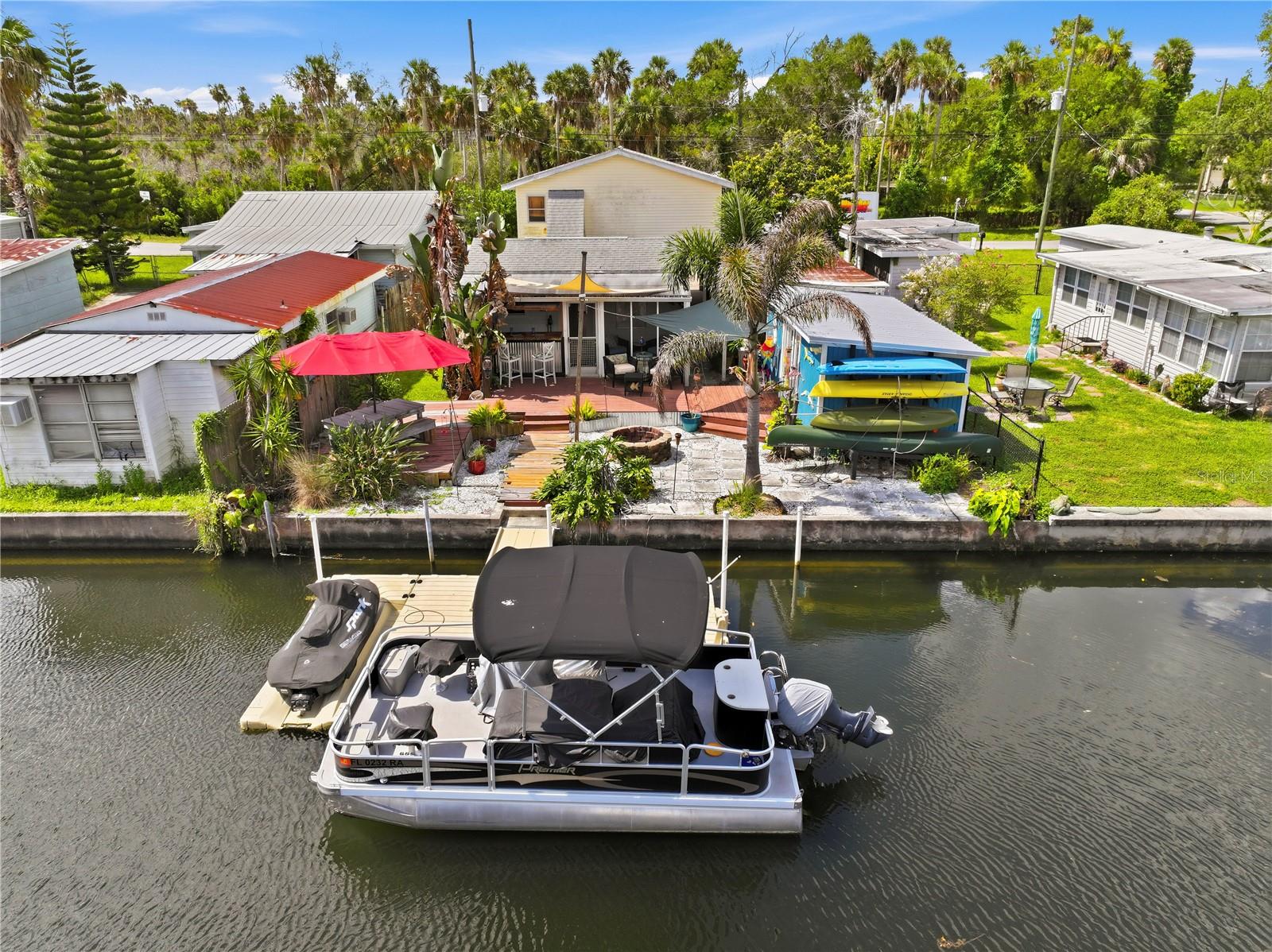 This WEEKI WACHEE waterfront retreat offers 3 bedrooms and 3 full bathrooms. The newly remodeled kitchen opens to the main living areas and features stainless-steel appliances, luxury vinyl flooring, and a custom butcher block island with a sink, garbage disposal, dishwasher, and seating. Perfect for additional entertaining is a screened porch with a Bar complete with sink area and pull up seating on both sides, extending to the large deck area complete with Fire Pit. Steps away from your private EZ Dock floating dock system with room to tie your boat and a jet ski ramping system. Direct access to the Gulf with your boat avoiding the hustle and bustle of the main river, yet close enough to Rogers Park and nearby attractions with frequent sightings of Manatees, fish, exotic birds, turtles, etc. Enjoy the Florida sunshine on this natural clear crystal water.  The property also includes kayak racks and a cabana room to keep water gear secure and organized.  Bring all your toys, this home features plenty of ground floor storage and parking. This golf cart community property is perfect for that staycation fun! With opportunity for short- or long-term income producing AIRBNB rental.  Close to Weeki Wachee Springs State Park, Nature preserves with hiking, biking, and nearby Marinas, a plethora of dining and shopping and a hospital less than a 10 min drive.  This property is a must see to appreciate its eclectic coastal charm.