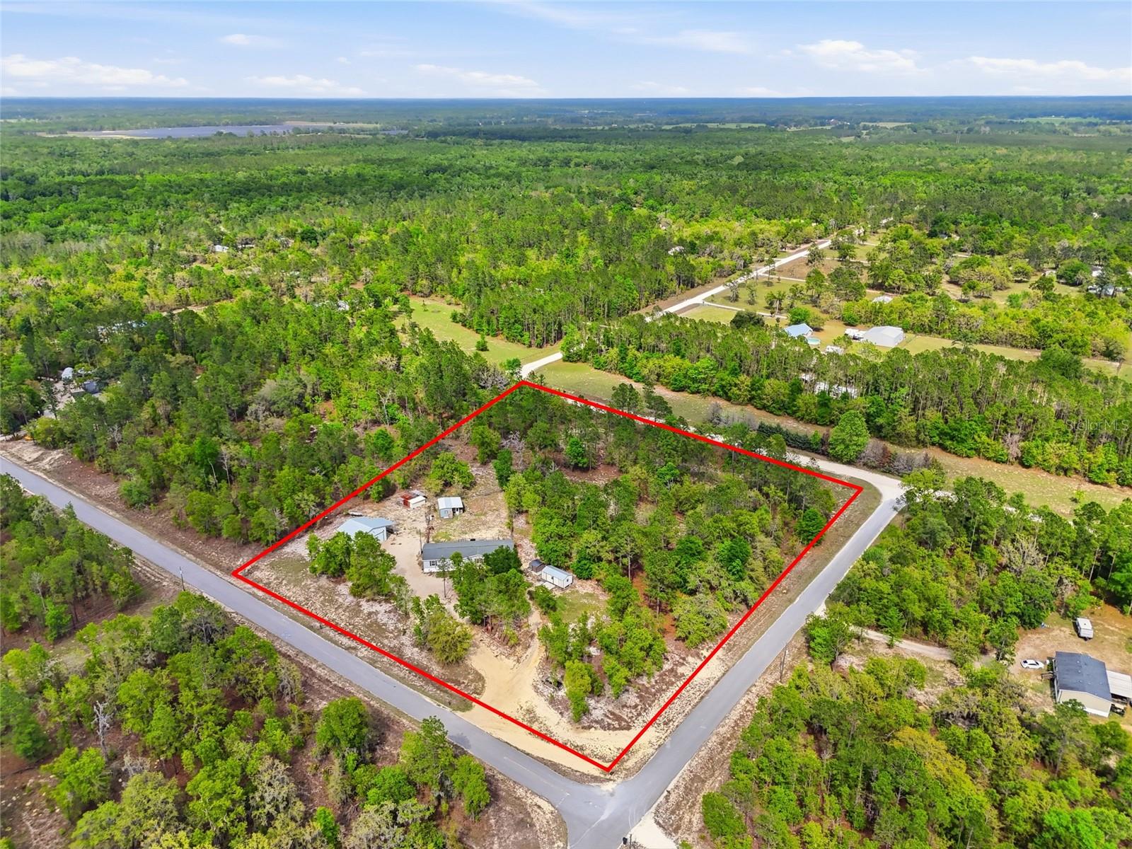 Located in Gilchrist County with a High Springs address, this 2019-built modular home sits on 5 acres and offers 4 bedrooms and 3 bathrooms with a split-bedroom layout and open living areas designed for comfortable everyday living and effortless entertaining.

What truly sets this property apart is the lifestyle. With five acres to call your own, you have the freedom to spread out and enjoy the quiet, slower pace that rural living offers—more privacy, fewer neighbors, and the space to truly make a property what you want. Whether it’s starting a garden, bringing animals, adding outdoor recreation features, or simply enjoying wide open skies and peaceful surroundings, this is a setting that allows you to live a little differently—in the best way.

The proximity to the Santa Fe River and some of North Florida’s most iconic springs enhances that lifestyle even further. Just minutes away, you’ll find Ginnie Springs, Gilchrist Blue Springs State Park, and Poe Springs Park—perfect for swimming, kayaking, paddleboarding, snorkeling, or simply unwinding by the water. Living this close means spontaneous afternoon river floats, weekend picnics at the springs, and year-round access to some of the clearest natural water in the state.

Back at home, the property offers two additional dwelling units (ADUs), giving you flexibility for multigenerational living, guest stays, home offices, or creative spaces. The detached workshop with a vehicle lift adds even more functionality, ideal for hobbies, projects, or equipment storage.

Despite the peaceful, tucked-away feel, you’re still conveniently located near High Springs for local dining and charm, with an easy drive to Gainesville for shopping, healthcare, and University of Florida events—giving you the perfect balance of privacy and accessibility.
