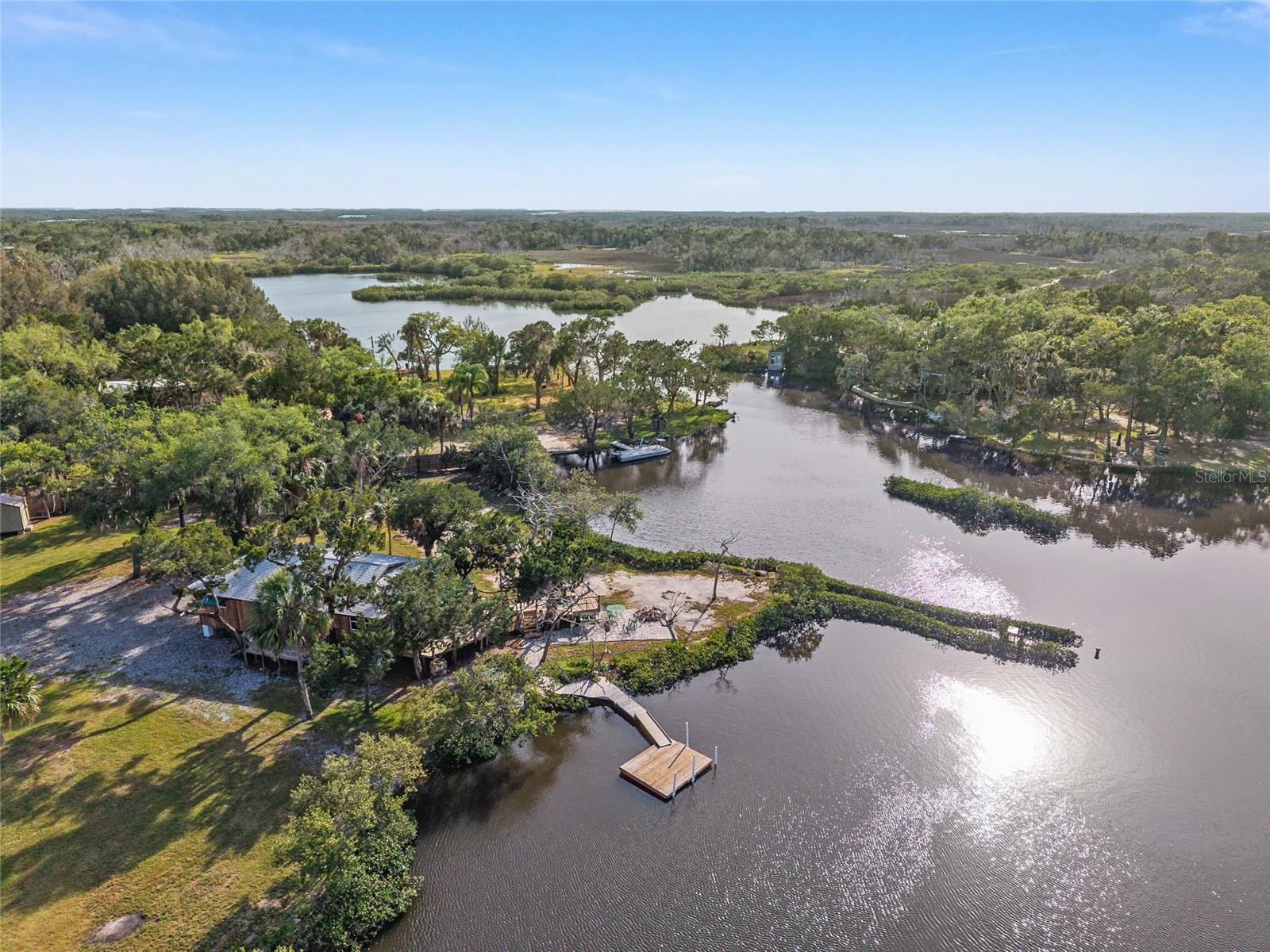 Discover a rare opportunity to own a private riverfront estate in Ozello, spanning 1.5 acres with over 500 feet of natural shoreline protected by a sturdy rock seawall. This expansive property is a sanctuary, fully enclosed by a privacy fence and offering vast space for vehicle and equipment storage. Just three miles from open waters of the Gulf of Mexico, this location is a premier gateway for world-class boating and fishing. The cypress-sided residence is designed to celebrate its unique setting, featuring over 1,000 square feet of attached decking with custom railings that overlook a constant parade of Florida wildlife, including dolphins, manatees and otters. The outdoor experience is further enhanced by a paved fire pit, and a floating dock. Inside, the home features solid wood cabinetry, durable tile flooring and newer windows, with a roof replaced in 2022 for added peace of mind. The primary suite serves as a tranquil retreat with direct deck access and water views, complemented by a primary bath with a tiled shower and updated vanity. Two additional bedrooms share a newly remodeled bath featuring modern lighting, built-in shelving and a fresh vanity. From vibrant birdlife, including pelicans, ospreys and spoonbills, to the seamless flow between the indoor and outdoor entertaining spaces, this estate offers a lifestyle of proven expertise in coastal relaxation and adventure.