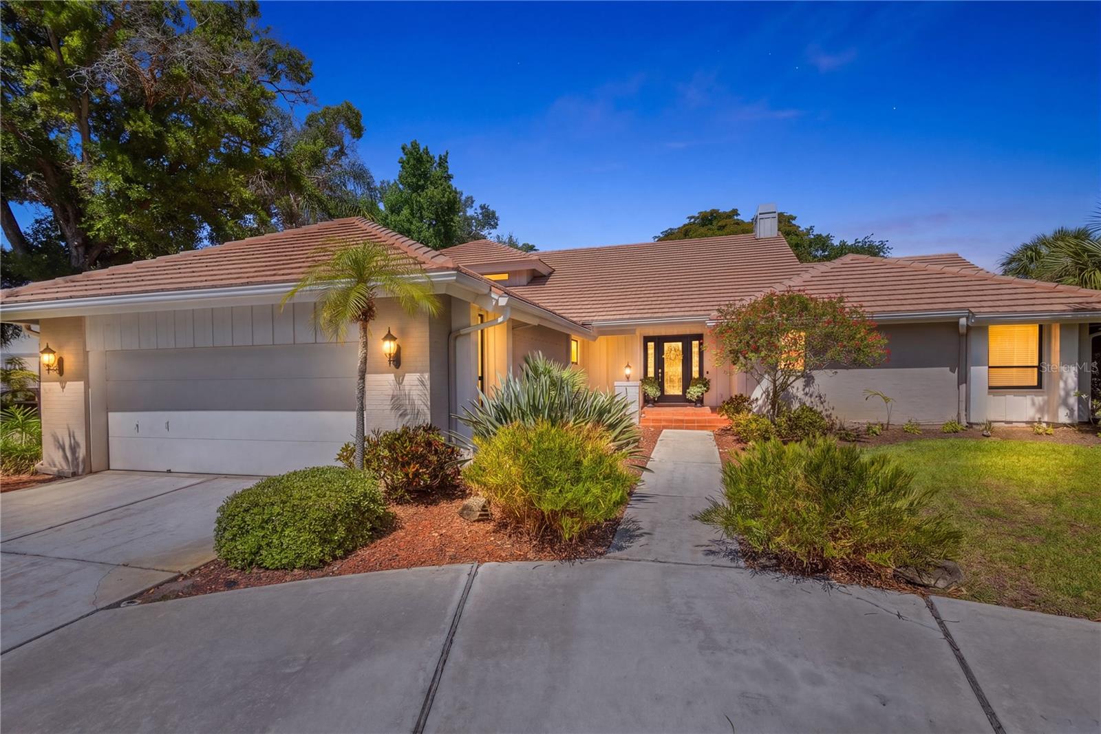 NOW OFFERED AT A SIGNIFICANTLY IMPROVED PRICE, this is an outstanding opportunity to own a custom WEST-OF-TRAIL home in one of Sarasota's most desirable GATED COMMUNITIES. Soaring ceilings and an abundance of natural light define this spacious 4-bedroom, 4-bath residence, thoughtfully designed and custom built by the original owner for both everyday living and effortless entertaining. Rich Cypress siding, elegant crown molding, plantation shutters, and imported Italian porcelain tile add warmth, architectural refinement, and timeless style throughout the home. The open floor-plan creates a seamless flow between living spaces, while a striking floor-to-ceiling white brick wood-burning fireplace serves as a dramatic focal point in the great room. Clerestory windows and skylights enhance the bright, airy ambiance, and custom built-in cabinetry compliments the home's clean, coastal-inspired design. Step outside to a private pool with an inviting setting for relaxing or hosting guests. A flexible office/den provides the ideal space for working from home or enjoying a quiet retreat, while generously sized bedrooms ensure comfort and privacy for family and visitors alike. Located within The Landings, a highly sought-after and gated West-of-Trail community, residents enjoy a lush, park-like environment with mature landscaping, scenic walking trails, and access to the Intracoastal Waterway. Community amenities include a kayak launch, kayak racks (as available), and a fishing pier situated at the end of a scenic nature trail, perfect for embracing Sarasota's waterfront lifestyle. Optional membership to the Landings Racquet Club offers tennis courts, a fitness center, clubhouse, and a vibrant social calendar. Ideally situated just minutes from downtown Sarasota, fine dining, shopping, and the world-renowned beaches of Siesta Key, The Landings offers an exceptional blend of privacy, natural beauty, and active living.