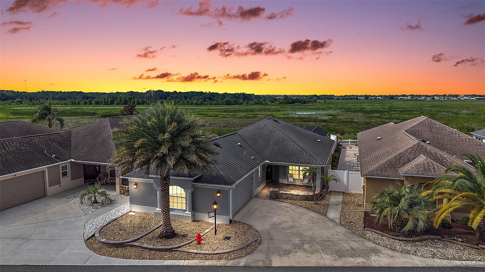 Experience exceptional WATERFRONT living in this MAGNIFICENT 3/2 Wyndham Courtyard Villa featuring a TWO-CAR GARAGE and an extraordinary collection of indoor and outdoor living spaces, including a FRONT PAVER PATIO, GLASS-ENCLOSED LANAI with MINI-SPLIT, EXPANSIVE PAVER BIRDCAGE with HOT TUB, REAR and SIDE PAVER PATIOS, and a PRIVATE PUTTING GREEN all set within the prestigious Village of Haciendas of Mission Hills! JUST MINUTES to LAKE SUMTER LANDING with live nightly entertainment! TIERED landscaping, front PAVER patio accented by a knee-high wall, and LEADED-GLASS entry with sidelight create a warm and inviting welcome. UPGRADES include ELEGANT CROWN MOLDING and THREE solar tubes that bathe the interior in NATURAL LIGHT. The OPEN-CONCEPT layout showcases LUXURY VINYL PLANK flooring, VAULTED ceilings, and an abundance of windows and sliding glass doors, creating a BRIGHT and EXPANSIVE main living area. The STUNNING kitchen features STAGGERED WOOD cabinetry, GRANITE countertops, TILE backsplash, STAINLESS appliances with a slide-in INDUCTION oven, DOUBLE BUILT-IN PANTRY, ROLL-OUT shelving, and LARGE U-SHAPED CENTER ISLAND that serves as both a functional workspace and casual dining area. From the living room, four-panel sliding glass doors open to a GLASS-ENCLOSED lanai with a MINI-SPLIT and TILE flooring. This INVITING space adds approximately 288sf of additional living area. An exterior glass door leads to an EXPANSIVE OUTDOOR RETREAT, where an 866sf PAVER birdcage with retractable awning and in-ground HOT TUB, and rear and side PAVER patios seamlessly connect, creating multiple  areas for relaxing, dining, and entertaining! There’s also a PRIVATE PUTTING GREEN! Fencing on both sides provides EXCEPTIONAL PRIVACY with peaceful, secluded WATER VIEWS! Back inside, the primary bedroom boasts a TRAY ceiling, WALK-IN closet, and DOUBLE windows overlooking the WATER. Its en suite bathroom features WOOD cabinetry with GRANITE countertop, TILE WALK-IN shower with frameless-glass, LINEN closet, and separate water closet. Bedroom two has been renovated to adjoin the primary suite and features a VAULTED ceiling, DOUBLE windows, and a built-in closet. A second bathroom features a WOOD vanity with GRANITE top and a TILE tub and shower combo. The third bedroom showcases a MURPHY BED with BUILT-IN DESK, ESPRESSO CABINETRY, and a built-in closet. Completing the package is a 513sf TWO CAR GARAGE with BUILT-IN WHITE cabinetry, laundry nook with additional WHITE cabinetry, utility sink, remote-controlled garage screen, attic access with stairs, and PLENTY of space for parking and storage! The quaint Village of Haciendas of Mission Hills is a a small, picturesque neighborhood that sits on the water with its own pool, bocce and shuffleboard courts, horseshoe pit, and postal facility. It’s IDEALLY LOCATED with BEAUTIFUL Lake Sumter Landing JUST ACROSS the water! Close to Hacienda Hills, Tierra Del Sol, and Palmers Legends Championship Golf and Country Clubs; Mira Mesa, Silver Lake, De La Vista, and Chula Vista Executive Golf Courses; Laurel Manor, and La Hacienda Regional Recreation Centers; and Coconut Grove, Cordoba, Rio Grande, and Chula Vista Neighborhood Recreation Centers. This amazing community is located directly off of CR466 with an abundance of shopping, dining, medical, banking, and more right at your fingertips! PLEASE WATCH OUR WALKTHROUGH VIDEO of this INCREDIBLE WATERFRONT HOME and call today to schedule your Private Showing or Virtual Tour!