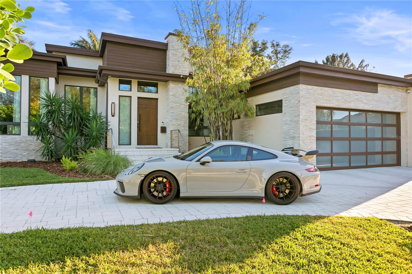 Immerse yourself in the lap of luxury within this one-of-a-kind single-story modern marvel, nestled in the prestigious Snell Isle Brightwaters enclave of St. Petersburg. Every detail of this residence has been meticulously curated to fashion an inviting and opulent ambiance. Upon arrival, the cove-lit great room beckons, bordered by expansive disappearing glass doors that seamlessly connect the interior to an outdoor sanctuary featuring a captivating pool and patios. At the heart of the home lies the open-concept chef's kitchen, a marvel designed for entertainment, boasting a 13-foot quartz waterfall island with seating for seven. Culinary wonders await with top-of-the-line Thermador appliances, including columnar wine units, freezer and refrigerator units, a 48-inch gas cooktop, steam and built-in ovens, and a Miele coffee station. Stylish functionality is further enhanced by a walk-in pantry.
Step outside to discover multiple water features and an infinity-edge spa, complemented by a striking covered outdoor kitchen. This al fresco haven includes a double gas fireplace, gas grill, refrigerator, sink, and a pass-through to the indoor kitchen. An additional seating area with a TV and fireplace elevates the entire outdoor setting, creating the perfect atmosphere for entertainment or relaxation.
The luxurious master retreat is a true sanctuary, opening to the pool areas and showcasing a spectacular shower, soaking tub, dual vanities, and two walk-in closets with custom cabinetry. Two additional bedroom suites feature designer baths and custom closets, ensuring comfort and style throughout the home.
The office, located off the foyer, exudes sophistication with custom 10-foot wood/bronze & glass barn-style doors. The powder bath is a work of art, boasting a vanity crafted from a tree removed during the property's transformation.
Additional amenities include a Sonos stereo system with 13 speakers, an all-house generator, and PGT hurricane impact windows, doors, and sliders, seamlessly combining luxury and security. Solar panels have been added to this ultra-modern home to enhance efficiency. This residence stands as a true masterpiece, offering a fusion of modern design, thoughtful functionality, and upscale living in the heart of Snell Isle. Don't miss out—schedule your appointment to view today!