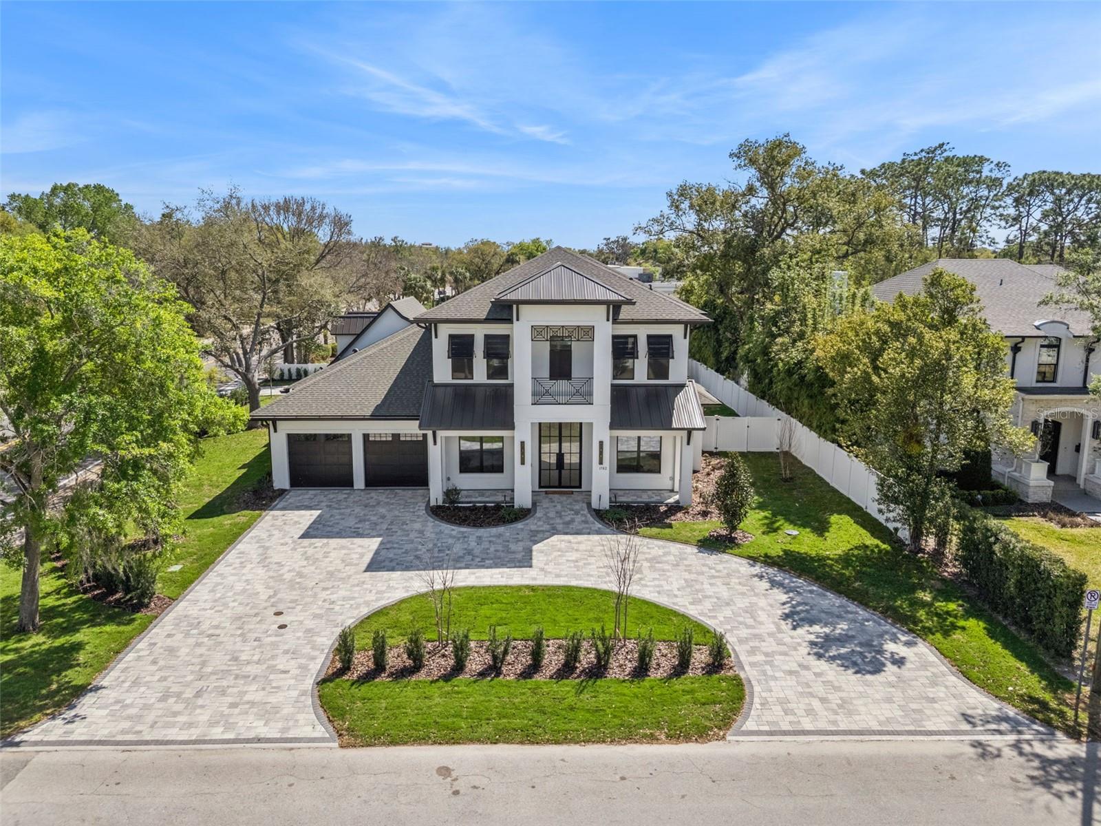 (HUGE PRICE REDUCTION & NEWLY ENHANCED REAR LANDSCAPING ADDED FOR EXCEPTIONAL PRIVACY AND MORE SECLUDED OUTDOOR LIVING EXPERIENCE) Step into this stunning West-Indies inspired luxury home crafted by Nautilus Homes, where tropical charm meets timeless elegance. An architectural masterpiece in the City of Winter Park. This five-bedroom seven-bath home that includes a private in-law suite offers plenty of exquisite interior features. The home welcomes you with a beautifully designed 16 ft wide circular driveway wrapped in upgraded pavers, offering both elegance and functionality. A very rare 4-car garage in Winter Park with two in the rear and two in the front of the home. Starting with entering through massive 10 ft. double iron doors flowing into the foyer with 11ft high ceiling beginning with the flex/office room and formal dining to your left and right. Followed by entering the gallery that leads to the great room. The Chef’s Kitchen, a culinary dream featuring an oversized center island, quartz countertops throughout, custom 42"+15" wood cabinetry, a custom walk-in pantry, and top-of-the-line Thermador professional series. That Includes a 48' refrigerator, 48" gas cooktop, custom hood, dishwasher, built-in microwave, double convection ovens and built in coffee station. On your way to the formal dining, you pass by the show-stopping, Tempered glass wine room. Its crystal-clear glass enclosure offers a striking view of your curated collection, while the built-in wine chiller ensures each bottle is perfectly preserved. This elegant transition creates a seamless blend of function and sophistication, setting the tone for unforgettable dining experiences just steps away. The primary suite offers tranquility peace of mind, and the primary bath has a spa-like oasis with a spacious shower stand-alone tub. Followed by a custom closet thoughtfully design with plenty of room and storage. The guest retreat area has a huge bedroom, access to a full bath including private access to the Lania and pool. Tucked away with its own private entrance attached to the rear garage, the in-law suite above the garage offers the perfect blend of comfort and independence. This thoughtfully designed space includes a full bath, a cozy living area, and a convenient space with a kitchenette—ideal for extended stays or multi-generational living. Make your way to the second floor that has 11ft ceilings as well. As you reach the top the space opens into a massive game room with a wet bar, perfect for entertainment retreat with a balcony. All second-floor bedrooms have a thoughtfully design with a full bath for privacy. As you make your way back downstairs to outside, step through the oversized sliding glass doors and into your private outdoor oasis. Effortlessly extending your living space into the open air. Just beyond, the sparkling gas heated/saltwater pool and spa framed by lush landscaping and designed for both relaxation and recreation. Also, the fully equipped summer kitchen features gas grille, beverage refrigerator and ample counter space—perfect for alfresco dining and effortless entertaining. This masterpiece is equipped with a full irrigation system around the home, exterior lighting, exterior cameras for security. Smart home system ready for lighting, music and security controlled by Control 4 system for your convenience.  Interlachen Golf community less than 5 min, Phelps Park walking distance, Park Ave 10 min and restaurant and retail minutes away.