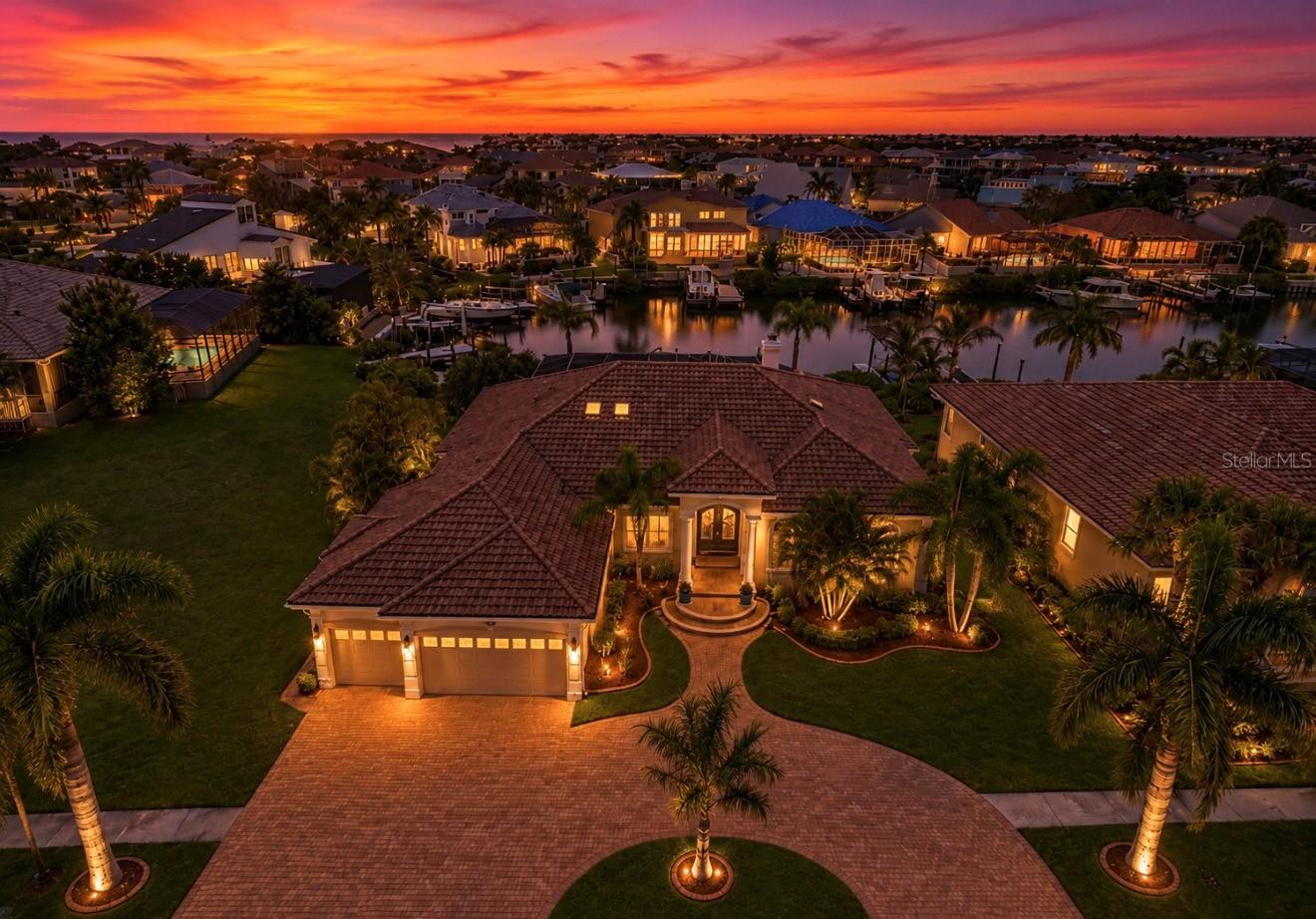 Immerse yourself in one of Symphony Isles' most breathtaking waterfront estates, where resort-style living meets timeless sophistication. A grand pavered circular driveway unfolds to reveal a stately ranch-style residence whose curb appeal leaves a lasting impression.

Step inside through double doors to a realm of soaring ceilings and an expansive, light-filled family room anchored by a gas fireplace and commanding water views. The open-concept kitchen is a chef's dream, featuring pristine white cabinetry, luxurious stone countertops, and top-tier stainless steel appliances. A large breakfast nook with private pool and water vistas anchors the casual living experience, while a formal dining room provides an elegant setting for exquisite entertaining.

The regal master suite showcases tray ceilings, tranquil sliders to the pool, two walk-in California closets, and a spa-inspired en-suite bath with a garden tub, stone floors, a glass-enclosed shower, and dual vanities. Three additional bedrooms and a generous bonus room offer flexible spaces for guests and entertainment. The bonus room opens to the pool deck and includes a pool table for effortless recreation.

Luxurious detailing runs throughout the home, including tile flooring, luxury vinyl plank, crown molding, plantation shutters, upgraded lighting, and ceiling fans! Outdoor living is nothing short of extraordinary: a screened-in pool and lanai with rock waterfalls, a Jacuzzi, expansive deck, and a high-end putting green create a resort-like atmosphere. A large dock with a 12,000-lb boat lift completes this waterfront sanctuary.

Additional highlights include a newer roof, newer AC, and a host of thoughtful upgrades.

Symphony isles is a manned gated 24/7, private roads, private beach, private boat ramp, every home is unique type of community where you can find a large sense of community and belonging, like a family!

Schedule your private showing today and experience the unparalleled luxury of this extraordinary residence