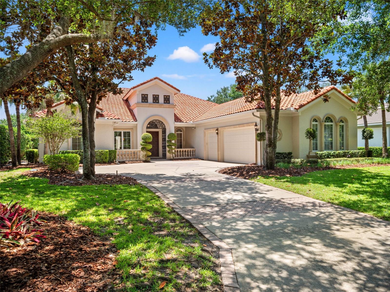 One or more photo(s) has been virtually staged. Welcome to a beautifully designed, custom, one-story pool home offering just under 3,500 square feet of thoughtfully designed living space on an expansive 0.35-acre homesite. Featuring a timeless Mediterranean exterior paired with a beautiful, transitional interior, this exceptional residence blends warmth, elegance, and modern style while being perfectly positioned on a quiet double-ended cul-de-sac street with gorgeous pond views. A stunning iron gate entry creates a grand first impression, leading to double front doors that open beautifully into the foyer and formal living and dining spaces beyond. From the moment you enter, the home showcases spacious interiors filled with natural light, unique light fixtures, and seamless indoor-outdoor flow designed for both everyday comfort and elegant entertaining. Designed with a functional split-bedroom floor plan, the home offers privacy and flexibility for everyday living. One wing of the home is dedicated to the spacious primary suite, creating a peaceful retreat complete with serene pool and pond views and a spa-like primary bathroom with dual vanities. On the opposite side of the home, two secondary bedrooms share a full bathroom, while a privately situated fourth bedroom toward the rear of the home is paired with an additional full bath, ideal for guests, multigenerational living, or a private office setup. The kitchen overlooks the main gathering spaces and out to the sparkling pool and tranquil water views, creating the perfect setting for entertaining. A large flex room at the rear of the home overlooks the pool and pond, offering endless possibilities for a media room, fitness space, playroom, or additional lounge area. The office features dual built-in desks, providing a stylish and functional work-from-home environment, while the interior laundry room with a window adds both convenience and natural light. Step outside to enjoy the covered lanai and screened pool area, ideal for relaxing, dining, and entertaining while taking in the peaceful pond views and beautiful Florida sunsets. The oversized homesite provides added privacy and generous outdoor space rarely found in the area. Combining timeless architecture, stylish interiors, and an exceptional homesite, this home offers luxurious Florida living in a peaceful and highly desirable setting. This is more than just a beautiful home, it’s a lifestyle. Nestled within the gated Lake Nona Golf & Country Club, residents enjoy 24-hour security, A-rated schools, and close proximity to Orlando International Airport, Medical City, Boxi Park, fine dining, shopping, and major expressways (417 Greenway and 528 Beachline) for convenient access throughout Central Florida. Ideally located just minutes from Orlando International Airport, Lake Nona Medical City, USTA National Campus, Boxi Park, and top-rated A-schools, this property also offers easy access to the 417 Greeneway and 528 Beachline. Don’t miss out on this opportunity!