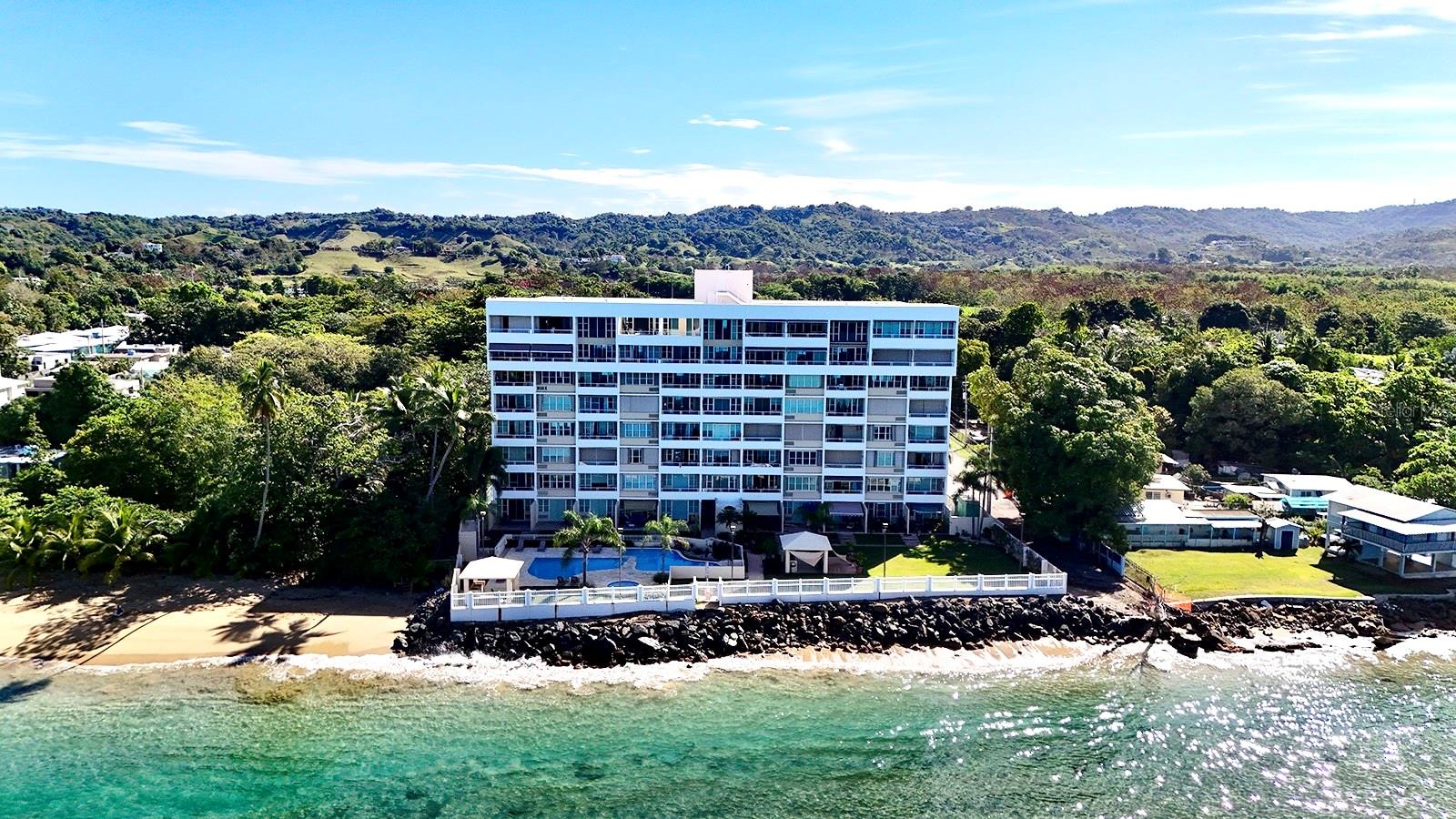 Fourth-floor residence at Pelican Reef Condominium in Rincón, Puerto Rico, offering unobstructed ocean views and effortless coastal living with direct beach access. This turnkey 2-bedroom, 2-bath unit is filled with natural light and refreshing ocean breezes, thoughtfully positioned to capture both privacy and sweeping ocean views, with front-row sunsets from your own space.
Residents enjoy access to a pool, private laundry closet, and one assigned covered parking space. Perfectly situated walking distance to pickleball courts, a running track, gym, and the local sports complex, the property sits in one of Rincón’s most active and convenient lifestyle corridors. Just minutes away, you’ll find restaurants, pharmacies, schools, and direct access to Road 115 for easy connectivity.
Whether as a primary residence, vacation retreat, or income-producing investment, this offering presents a compelling blend of location, views, and turnkey convenience in one of Rincón’s most sought-after markets.