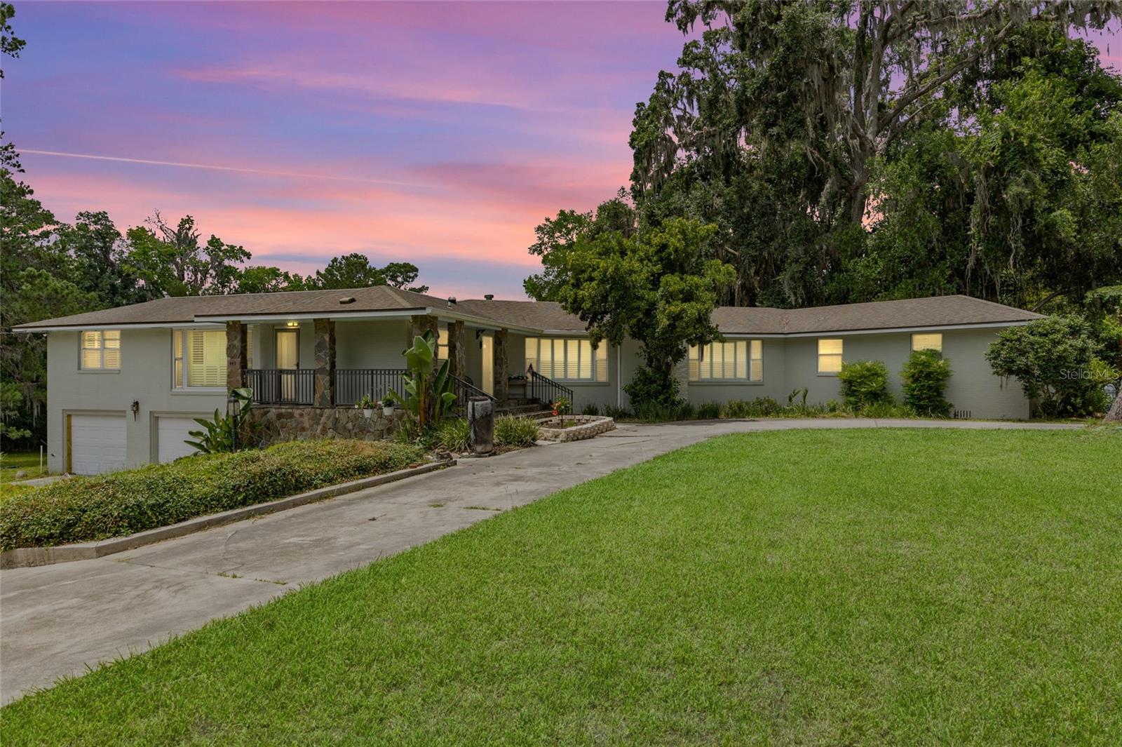 Make sure to check out the Virtual Tour for a 3D Model w/ Walkthrough, Floor Plan w/ Measurements, Video, & more! If you’ve ever dreamed of living in a lakeside retreat with a tennis court, a gazebo, storage shed/carport and a dash of old-school charm, this 1951 classic on “Doctors Row” might just be your prescription for happiness! This two-story beauty offers a new flat roof over sunroom 2023, 3,075 sqft of heated and cooled living space on a sprawling 3.41-acre lot. Featuring 4 bedrooms with TWO Master Suites, a bonus room/office/den, 3 full baths and 2 half-baths PLUS a living room, sun room, formal dining, and TONS of storage space! Laundry? No problem! This home offers you a choice of upstairs/inside laundry hookup or downstairs/garage laundry hookup! (Maybe choose both because who wouldn't want to get all of the laundry done WAY faster!?) The grand living room features beautiful hardwood floors that flow throughout most of the home, a wood-burning fireplace, rich paneling, crown molding, wainscoting, plantation shutters, and soaring 10-foot ceilings. The sunroom, adorned with brick accents and more plantation shutters, opens onto a large deck overlooking the back yard and the lake - perfect for morning coffee or evening relaxation.  Speaking of views, almost all the windows in the home have been replaced by Anderson Windows in 2023. The kitchen is equipped with stainless steel appliances, a commercial-grade gas range and hood, and a trash compactor ready for your culinary adventures. The expansive 18x20 main master suite boasts a private balcony overlooking Lake Montgomery, offering serene water views to start and end your day. The circular driveway leads to a large front porch (equipped with leaf guard gutters), inviting you to sit and stay awhile. Out back, enjoy the gazebo, dock/fishing platform, and a tennis court that might just inspire your inner Serena or Roger. The large rear deck is ideal for entertaining, barbecues, or simply soaking in the natural beauty that surrounds you. Located on the affectionately dubbed “Doctors Row,” this home is nestled in a community known for its charm and character. You're just minutes away from downtown Lake City, where you can explore the Lake City-Columbia County Historical Museum, enjoy events at The Blanche, or dine at local favorites like Halpatter Brewing Co. Outdoor enthusiasts will appreciate the proximity to Alligator Lake Recreation Area, offering trails, fishing, and birdwatching opportunities. This Lake City gem combines classic elegance with modern amenities, all set on a picturesque lakeside lot. Whether you're hosting gatherings, enjoying outdoor activities, or simply relaxing in your sunroom, this home offers a lifestyle that's both comfortable and captivating.