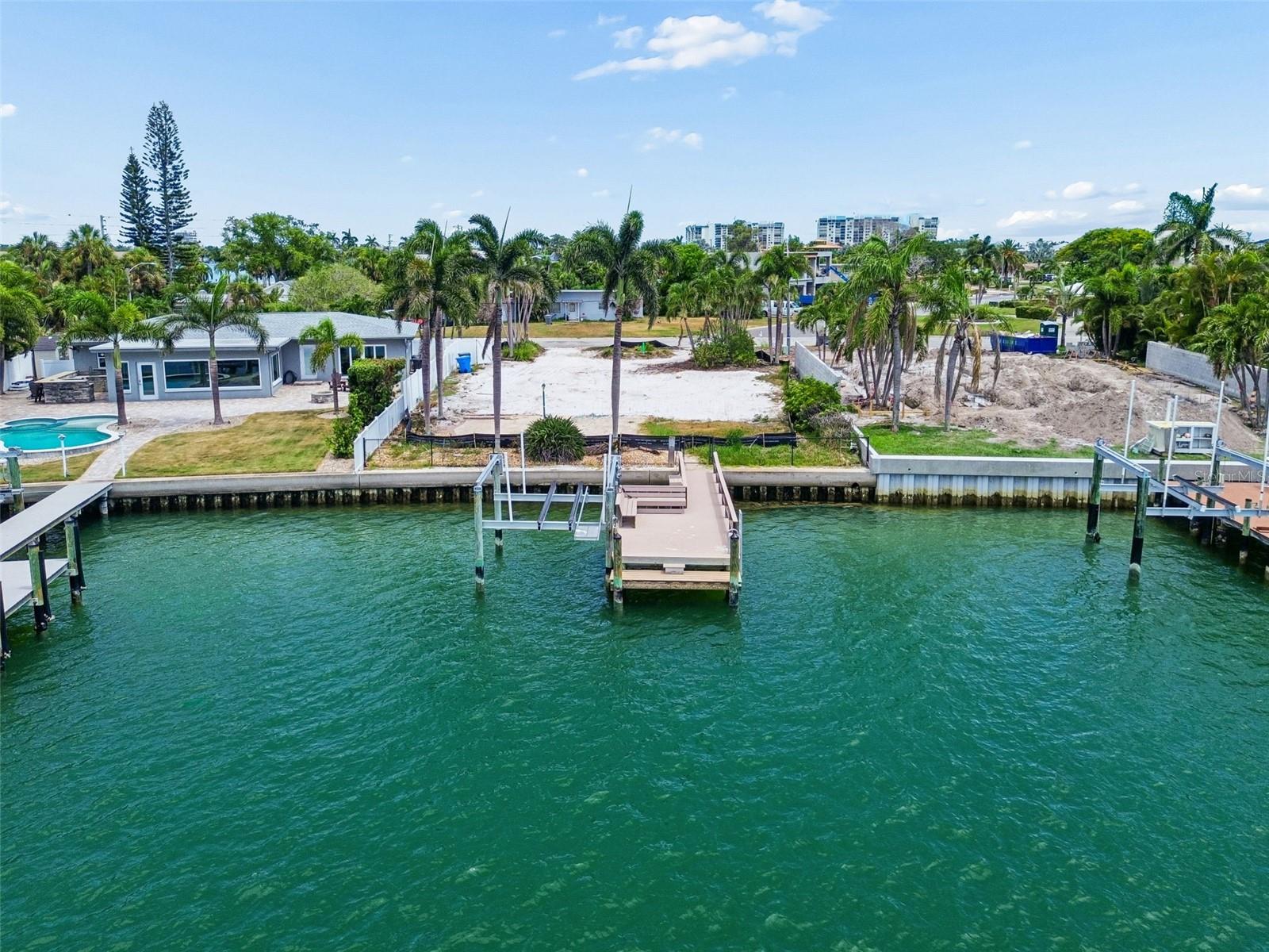 Build your dream home on this prime deep waterfront lot on Paradise Island. Situated on an extra wide canal, this 9,540-sf lot offers 65 feet of deep-water frontage providing amazing northwest views of the gulf and amazing sunsets. With water access to Boca Ciega Bay, the boat life is complete with a composite dock featuring water and electric, bench seating, step down for paddle board or kayak launch and 11,000 lb boat lift! The gulf is just minutes away via the intercoastal waterway via John's Pass. Paradise Island neighborhood gives the feeling of community an active lifestyle and features Treasure Bay Tennis and Pickleball Club right down the street. Treasure Island beach is a short drive or slightly longer walk away. Grab some groceries at Publix or dine at the many waterfront restaurants by boat. Access to I275 to Tampa or South to Bradenton / Sarasota is directly east about a 15-minute drive and downtown St. Pete is just another 10 minutes east. Live the island life - build your dream home on this amazing waterfront lot in Paradise!