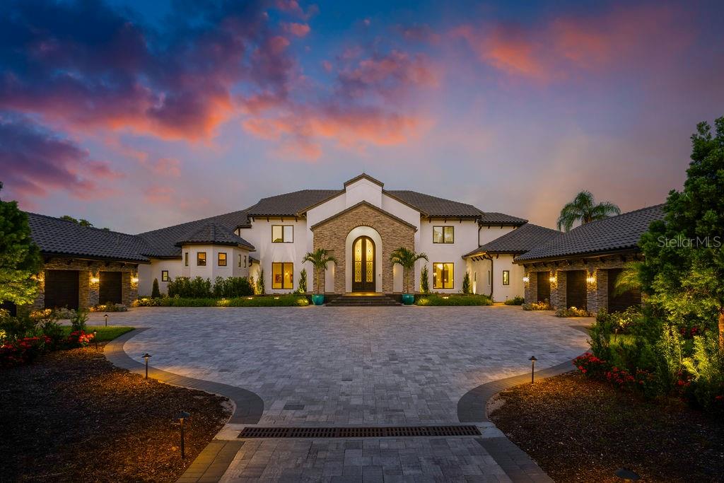 Welcome to Maison du Lac – a breathtaking lakefront estate that epitomizes unrivaled luxury, timeless elegance, and an extraordinary lifestyle. Situated on an expansive 2.7-acre lot along the prestigious Winter Park Chain of Lakes, this extraordinary residence showcases over 120 feet of pristine lakefront with sweeping panoramic views of the longest stretch of Lake Maitland.
Blending classic Mediterranean architecture with state-of-the-art modern enhancements, Maison du Lac is a stunning fusion of enduring charm and contemporary sophistication. Originally constructed with timeless materials – including stucco exteriors and expansive windows – the home has been meticulously transformed into an 11,668-square-foot architectural masterpiece. Clean lines and open-concept living harmonize with rich textures and refined details, resulting in an environment that is both stately and smart.
Upon entering through the grand 14-foot custom iron door, you are greeted by soaring dual staircases and exquisite finishes in marble, granite, and intricate moldings that reflect the home’s bespoke craftsmanship. A showstopping, $250,000 crystal chandelier—custom-designed and operable at the touch of a button—crowns the expansive great room, setting a dazzling tone for the professionally curated interiors. A private elevator adds convenience and accessibility across all levels of the home.
The fully reimagined kitchen is a culinary showpiece, featuring top-of-the-line Wolf appliances, gleaming Cambria countertops, a large walk-in pantry, and expansive prep space ideal for entertaining at any scale. Whether hosting a lavish dinner or a relaxed brunch, the kitchen delivers both impeccable style and everyday functionality.
The private master wing is an indulgent retreat, complete with a cozy fireplace, executive office, sauna, fitness room, and dual custom walk-in closets. Five additional en-suite bedrooms are thoughtfully positioned for maximum privacy, offering luxurious accommodations for family and guests. With seven full bathrooms and three half baths, the residence is ideally equipped for both refined daily living and grand-scale entertaining.
For effortless indoor-outdoor living, multiple entertainment spaces flow seamlessly onto a sprawling lakefront patio. The outdoor summer kitchen, complete with a powered screen enclosure, provides the perfect setting for alfresco dining while enjoying sunset views over the water. A brand-new dock with a boat lift invites leisurely days spent boating, fishing, or simply relaxing on the lake.
Outside, the estate continues to impress. Two serene fishponds with fountains create a tranquil sense of arrival, while the fully fenced and gated grounds ensure ultimate privacy. The residence is equipped with a full-home LUTRON smart system, offering intuitive control of lighting, ambiance, and automation. Additional features include a six-car garage, a resort-style swimming pool, newly updated landscaping, and custom exterior lighting.
Maison du Lac is more than a home, it’s a lifestyle of distinction, privacy, and effortless sophistication. This is the lakefront living at its finest.
