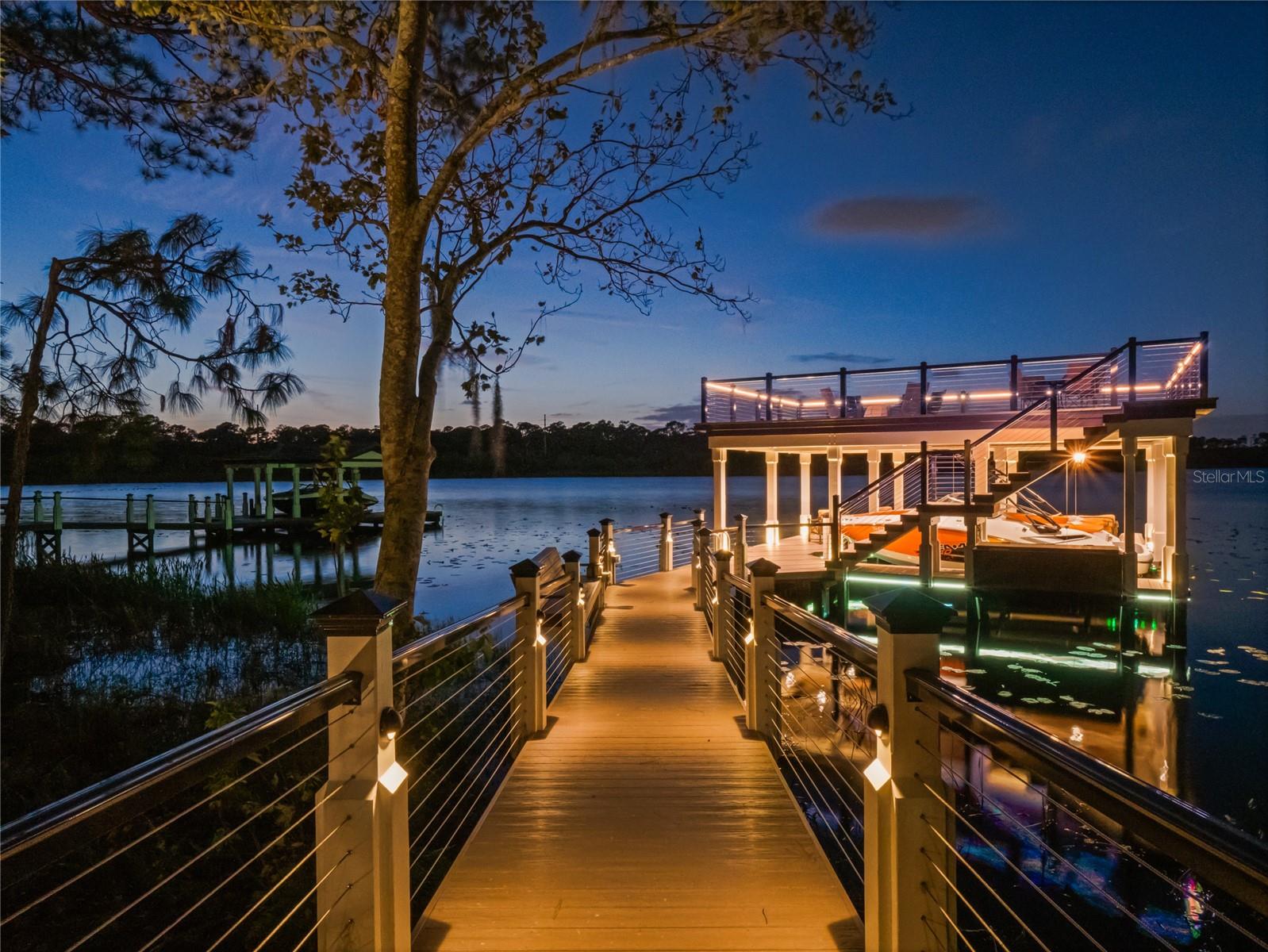 This stunning lakefront residence offers an unparalleled waterfront living experience 5 minutes away from Golden Oak, Four Seasons Resort and the Disney Parks complex. Encompassing 6 bedrooms, 5 ½ baths, and 4,168 sq. ft. of designer-finished luxury living space, this home is nestled directly across from Disney's conservation property, providing a serene private oasis surrounded by nature's beauty. The open-concept main living areas provide breathtaking views of pristine South Lake. Complete with an outdoor kitchen, built-in gas fireplace, and a custom pool and spa featuring a waterfall wall. Dual Owner Suites, one on each floor, each offer luxurious private baths, separate soaking tubs, and glass-enclosed rain-head showers. The second-floor Owner’s Suite boasts a modern glass-railed balcony with 180-degree view of South Lake, a convenient morning kitchen, and a private laundry adjacent to two oversized walk-in closets. The spacious loft serves as an ideal space for relaxing and entertaining, featuring a wet bar with a wine cooler. The gourmet kitchen is a culinary dream, with upgraded cabinetry, Wolf & Miele appliances, Quartz countertops, and a large walk-in pantry. Outside, enjoy an expansive living area, including a rare two-level boat dock offering over 1,000 sq ft of outdoor living space over the water. The perfect place relax and watch the Disney fireworks each evening. Located in the exclusive, private, gated community of Royal Cypress Preserve, this home is one of only three luxury homes on the lake. The community offers resort-style amenities, including a clubhouse with a zero-entry pool, fitness center, lawn and landscape maintenance, and more. This stunning residence is just minutes from area attractions, world-class shopping, and fine dining. A Toll Brothers Signature Executive home, every detail of this home has been thoughtfully designed to create a peaceful, luxurious retreat, making this a rare opportunity to own a breathtaking lakefront property in one of Orlando’s most coveted locations.