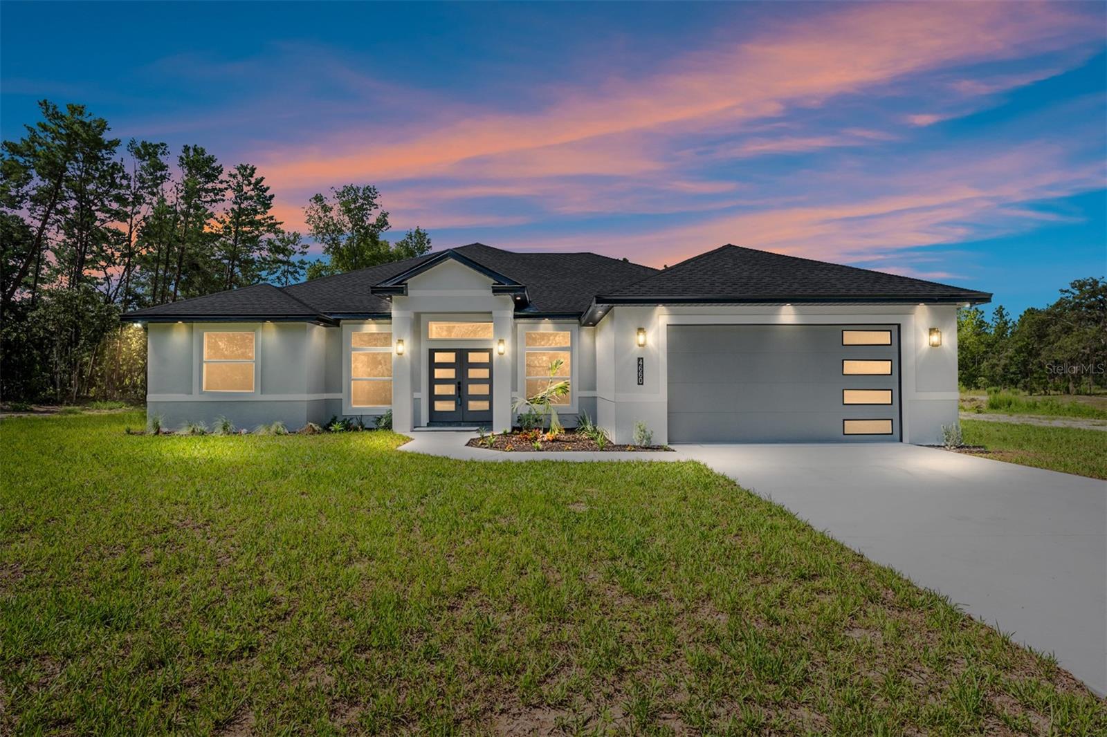 Virtually Staged. Welcome to this exceptional brand-new construction home situated on a beautiful 1-acre homesite, where luxury finishes and thoughtful design come together to create a truly one-of-a-kind property. Offering 4 spacious bedrooms, 3 full bathrooms, and oversized polished tile flooring throughout, every inch of this home has been carefully crafted with quality and style in mind. The stunning kitchen is the centerpiece of the home, featuring modern two-tone cabinetry with abundant storage, an oversized waterfall island with cabinetry on both sides, a built-in wine refrigerator, upgraded fireclay farmhouse sink, elegant gold lighting accents, quartz countertops that run into the backsplash and premium finishes that make both everyday living and entertaining effortless. The luxurious primary suite and guest bathrooms continue the home's upscale feel with frameless glass shower doors, illuminated smart mirrors, designer fixtures, and high-end finishes.. High baseboards, custom details, and exceptional craftsmanship can be found in every room. Step outside to your covered lanai, already designed for entertaining with ceiling fans, recessed lighting, a summer kitchen setup, and durable epoxy flooring—creating the perfect outdoor living space to enjoy Florida living year-round. Homes with this level of detail, craftsmanship, and upgrades are rarely available. From the premium finishes to the functional layout, this property offers luxury that stands apart from typical new construction. Schedule your private showing today and experience everything this remarkable home has to offer.