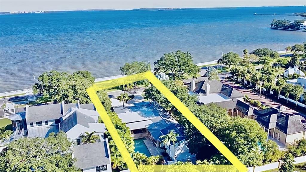 A rare find — this gorgeous turn key trophy home looks out on the blissful waters of Tampa Bay. The magnificent luxury one-story home is nestled on the highly sought-after, Bayshore “Billionaire” Boulevard. Elegantly remodeled to highlight a gorgeous midcentury-modern interior, cascading light from the enormous picture windows and 70 feet of breathtaking waterfront views framed by downtown Tampa's skyline. Inside, the wide-open spaces are ideal for Southwest Florida living. four bedrooms, four-and-a-half baths, plus an above-garage guest suite complete this magnificent property. Perfect for entertaining, the pristine gourmet kitchen has been beautifully updated with granite waterfall countertops, porcelain tile and a Viking gas stove. Accompanying the kitchen, you'll find a freshly designed wet bar updated with new granite countertops and floating shelves adjacent to the voluminous family room, plus a temperature-controlled 450-bottle wine room to house your favorite collections. Restore and rejuvenate in the generous first-floor master suite, boasting refinished bamboo flooring and French doors. The huge master bath features dual vessel sinks, new stone and tile accents and an exquisite rainfall shower. Outside, through French doors, a true tropical oasis begins to come together with lushly landscaped swaying palms, an oversized pool, an outdoor kitchen with a built-in grill, a wet bar with countertop seating and a convenient pool half-bath. This home is complete with a rear-entry two-car garage, paved circular driveway and ample parking spaces in the front and back.