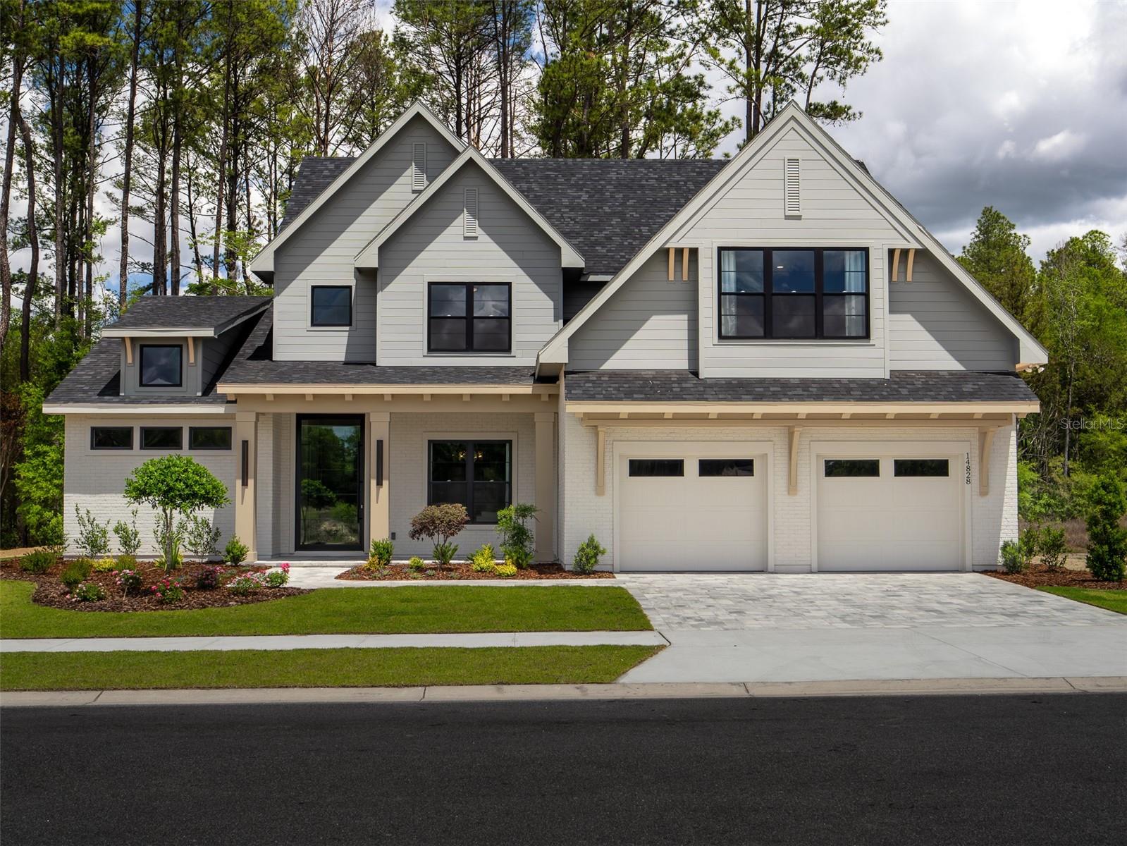 Majestic modern design meets elevated luxury in this exceptional new construction semi-custom estate, thoughtfully crafted with timeless architecture, curated designer finishes, and impeccable attention to detail throughout. This warm minimalist-inspired two-story residence offers 4 Bedrooms, 4 Bathrooms, a private Study, Bonus Room, sparkling Pool, Summer Kitchen, and an oversized 3-Car Tandem Garage—perfectly balancing sophisticated entertaining with comfortable everyday living.
A dramatic 5-foot-wide by 10-foot-tall pivot front door creates a breathtaking first impression, opening into a grand Foyer with soaring two-story ceilings that continue into the stunning Great Room. Anchored by a sleek fireplace and an impressive 16’ x 10’ glass bi-fold slider, the living space seamlessly blends indoor and outdoor living, opening to the expansive Covered Lanai and resort-style Pool area.
The gourmet Kitchen is both striking and functional, featuring a large double-sided island, custom painted wood cabinetry, oversized designer hood, and premium 48” LG Signature Range and 48” LG Signature Refrigerator. A spacious walk-in Pantry with built-in shelving, microwave, and direct Garage access adds convenience without compromising style. Just beyond, the Dining Room is flooded with natural light from five oversized windows overlooking the Pool and Covered Lanai.
Privately situated, the luxurious Owner’s Suite serves as a tranquil retreat with abundant natural light and vaulted ceilings. The spa-inspired Owner’s Bath showcases a freestanding soaking tub, oversized walk-in shower, and an expansive custom walk-in closet complete with built-in shelving and designer finishes.
The first floor also includes a private Study, beautifully designed Laundry Room with LG Washer and Dryer, Mud Room, and a Full Bath with direct Pool access. Throughout the home, elevated craftsmanship is showcased through 7-inch baseboards, solid-core interior doors, custom trim work, designer wallpaper, black exterior window frames, and thoughtfully integrated custom built-ins with a wine refrigerator beneath the staircase.
Designed for year-round entertaining, the Covered Lanai is fully equipped with a Summer Kitchen featuring all-weather cabinetry, countertops, plumbing, and grill. Built with both luxury and efficiency in mind, the home also includes open-cell spray foam insulation, double-pane insulated Low-E windows, two gas tankless water heaters, and a Carrier Performance Variable-Speed Compact Heat Pump system for superior comfort and humidity control. The home is HERS certified and includes a 2-10 Builder Warranty for added peace of mind.
Located within The Sanctuary of Laureate Village, residents enjoy modern homesites requiring less yard maintenance, surrounded by preserved green spaces and access to resort-style amenities including a community pool, pickleball courts, putting green, playground, basketball court, scenic walking trails, and convenient connectivity to the Town of Tioga.