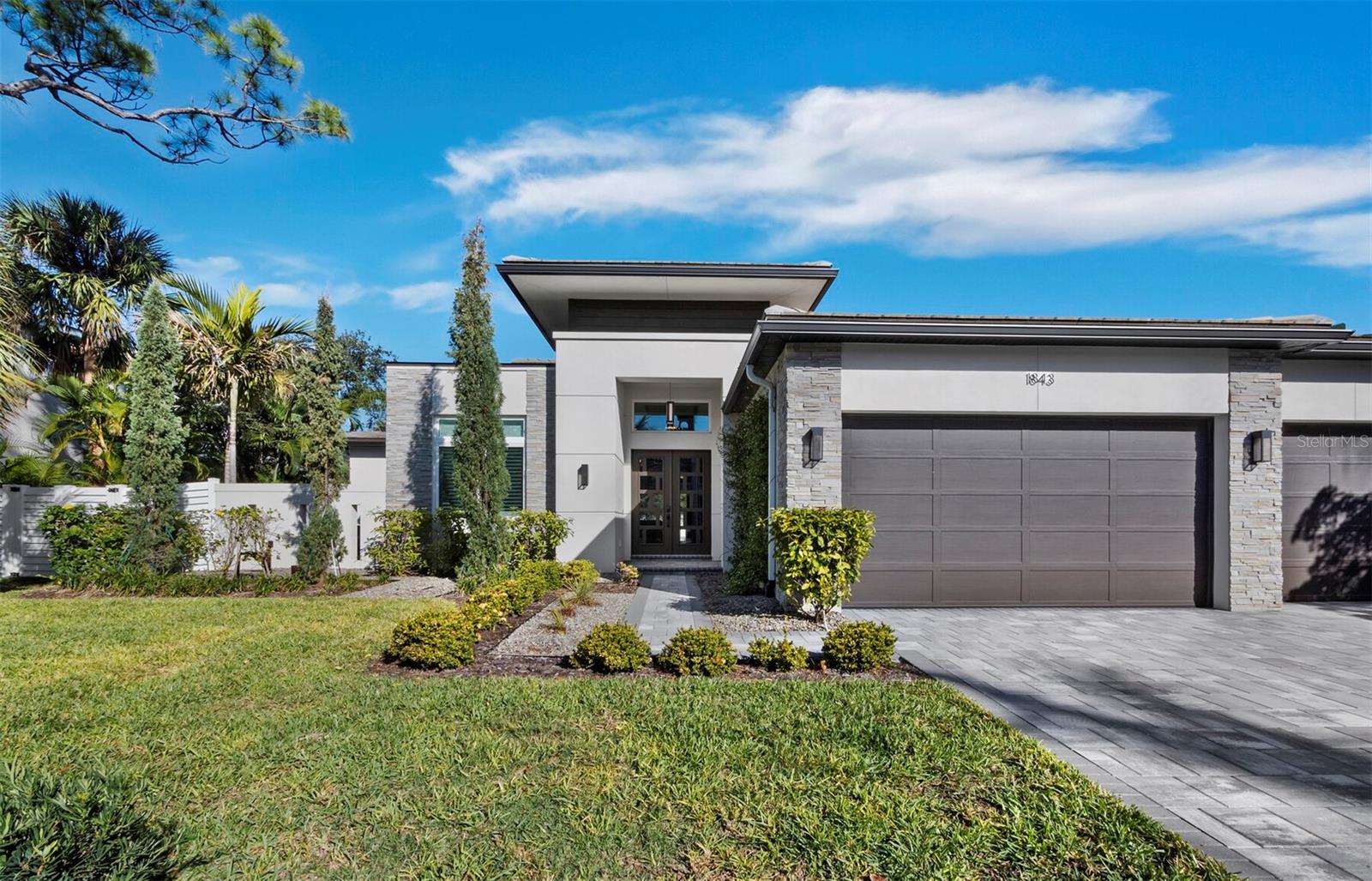 This exceptional soft contemporary single story home, built in 2022, is a former model home by Allegra Homes and features numerous upgrades and custom built-in details. Offering 3 bedrooms, 3 full and 2 half bathrooms, an office, and multiple outdoor living spaces, the home features an open floor plan with high ceilings, allowing an abundance of natural light. The kitchen includes a large waterfall-edge island with seating, Sub-Zero and Wolf appliances, ample storage, and a walk-in pantry. The dining area and both living areas have pocket sliding doors that create a seamless flow to the outdoor spaces and pool deck. The primary suite includes a large walk-in closet with built-ins, direct access to the laundry room, and a spacious bathroom with dual vanities, a zero-threshold shower, and a garden tub. Two additional bedrooms are en suite with walk-in closets. Additional features include a study with built-ins, tray ceilings, cove crown molding, and quality fixtures throughout. Outdoor amenities include a heated pool and raised spa, sun shelf, outdoor fireplace, summer kitchen, and panoramic screened lanai. The home also offers an oversized three-car garage (one of which has been converted into a home gym with air conditioning), hurricane impact windows, central vacuum, security cameras, a tankless water heater, and lush tropical landscaping. Situated in the desirable South Poinsettia neighborhood, west of the Trail, just steps from the shops and restaurants of Southside Village and a short drive to downtown Sarasota Bayfront, St. Armands Circle, and the beaches of Lido and Siesta Key. It is also located in the highly sought-after Southside Elementary School District. Book your showing today!