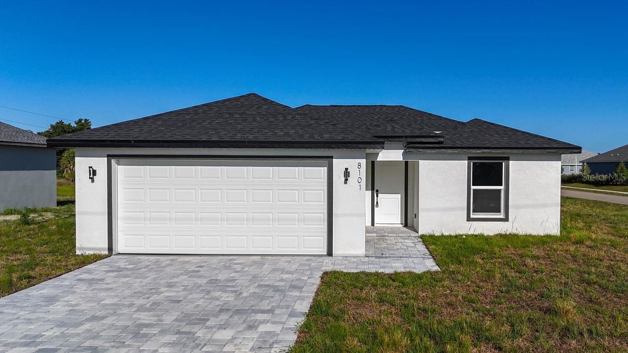 Welcome to this beautiful new construction home located in North Port, Florida. This property combines modern design, functionality, and comfort all on one level, offering 3 bedrooms, 2 bathrooms, and a 2-car garage, ideal for buyers looking for a brand-new home with contemporary finishes and a well-designed layout.

From the moment you arrive, the home stands out with its clean and elegant exterior, shingle roof, paver driveway, and modern curb appeal. As you enter, you will find an open-concept floor plan with excellent natural light, cathedral ceilings, and a layout that seamlessly connects the main living area, dining space, and kitchen, creating a spacious and comfortable environment perfect for everyday living or entertaining guests.

The kitchen is one of the most attractive features of the home. It offers modern white cabinetry, black hardware, a central island, light countertops, stainless steel appliances, and an open design that allows the kitchen to flow naturally into the social areas. The main living space features ceramic tile flooring with a wood-look finish, neutral colors, and a bright, open feel that makes it easy to decorate in a variety of styles.

The primary bedroom offers a comfortable space, a walk-in closet, and a private bathroom with modern finishes. The bathrooms feature contemporary details, light tones, black fixtures, and elegant surfaces that create a clean and sophisticated look.

The property sits on a spacious lot of approximately 10,906 square feet, with no HOA, no CDD, and located in Flood Zone X, offering a great advantage for buyers seeking more freedom, lower monthly costs, and peace of mind. The backyard provides excellent potential to design an outdoor area to fit the buyer’s lifestyle, whether for entertaining, gardening, pets, a future pool, or simply enjoying the open space.

This home is an excellent opportunity for buyers looking for a brand-new, modern, move-in-ready property in a growing area of North Port, with convenient access to main roads, shopping, services, restaurants, parks, and everything the area has to offer.

An excellent option as a primary residence, second home, or investment property. Modern, functional, with no HOA, and ready for its next owner. Easy to show. Schedule your private showing today and come see everything this property has to offer.