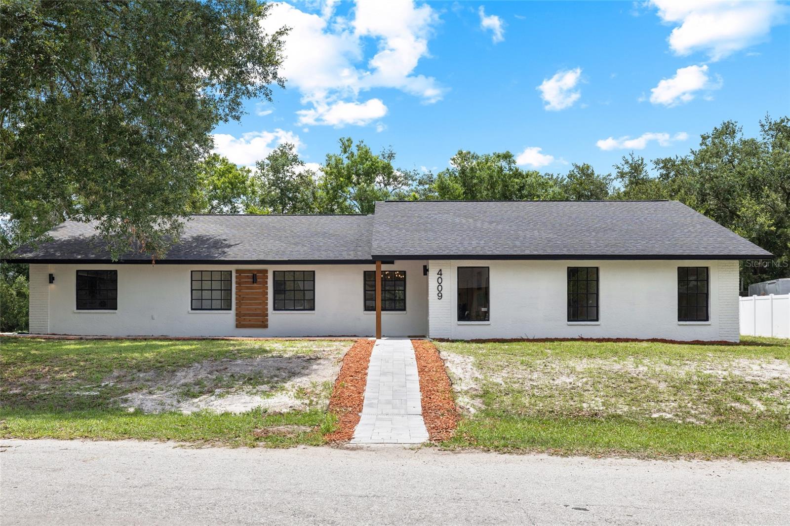 Welcome to 4009 Sprucewood Place, a beautifully renovated 4-bedroom, 2-bath home tucked away on a quiet cul-de-sac in Lake Padgett Estates East. Situated on a spacious 1/3-acre lot with no rear neighbors, this home offers privacy, modern updates, and plenty of room to enjoy both indoor and outdoor living.
The bright, open layout features vaulted ceilings, wide-plank waterproof vinyl flooring, recessed lighting, and a stylish kitchen with quartz countertops, a large island, breakfast nook, two-tone cabinetry, and brand-new stainless steel appliances (still under warranty). The living room is centered around a wood-burning fireplace and opens to an oversized screened porch overlooking the peaceful backyard.
The primary suite includes direct porch access, a walk-in closet, and a beautifully updated bathroom with dual sinks and an oversized walk-in shower. The home also features a spacious laundry room with generous cabinetry, counter space, and a utility sink. Additional highlights include a new roof (2026), a brand-new pavered driveway and walkway, and updated finishes throughout.
Lake Padgett Estates East is an established, amenity-rich community offering no CDD and low HOA fees of just $60 per month. Residents enjoy access to the community pool, clubhouse, fitness room, dog park, playground, tennis, basketball and racquetball courts, jogging track, batting cage, picnic area, and the members-only Hideout bar and lounge. The neighborhood offers a welcoming community atmosphere with plenty of opportunities to stay active, socialize, and enjoy the outdoors.
Conveniently located near the Land O’ Lakes Recreation Complex, Plantation Palms Golf Club, shopping, dining, Publix, and major roadways including SR-54, US-41, the Suncoast Parkway, and I-75. This location offers an easy connection to Tampa, Wesley Chapel, and surrounding areas while still providing the quiet neighborhood setting buyers are looking for.