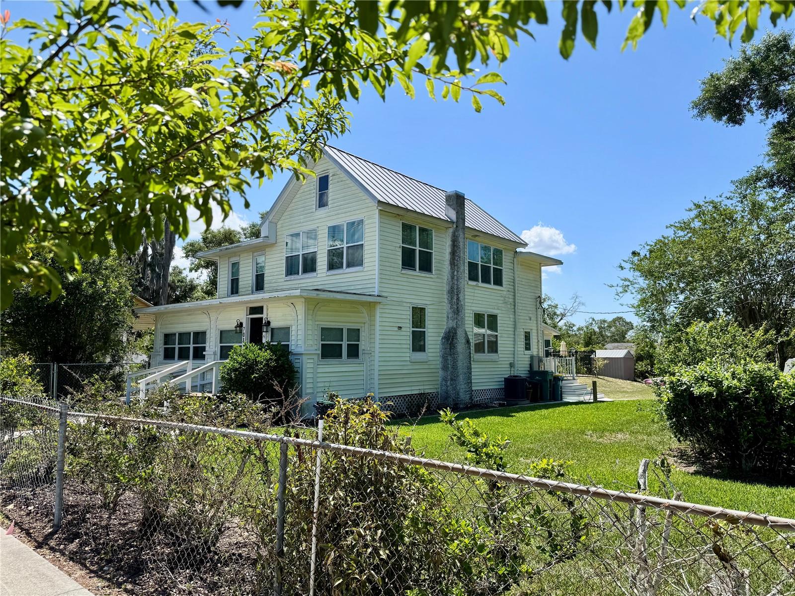 Welcome home.  Expect to be impressed.  Step into timeless charm with this circa 1925 VINTAGE home + a SPACIOUS "fully equipped" GUEST COTTAGE.  Experience a piece of Historic Eustis two blocks from Lake Gracie.  ***Also, a fantastic investment opportunity for your portfolio.  ***Currently a highly rated vacation rental, with the option of renting both the house and cottage as separate short-term rentals. With all service providers in place and the ability to seamlessly transition ownership, it offers an excellent rate of return. It rents well in both summer (because of the pool) and the winter (escaping the cold).  One of a kind recently renovated rare gem ready for making new memories.  Situated on an OVERSIZED and FULLY FENCED .40 acre CORNER LOT complimented with a lush, manicured lawn and a canopy of Majestic Oaks providing beauty and shade.  This unique property includes the 2,292 sq ft primary 4 bed/2 bath + 20 X 40 Lap Pool + detached Guest Cottage w/full kitchen/bath and its own gated private yard.  The primary residence has been lovingly updated with careful attention to detail to ensure respect for its original character.  Some improvements include: 36 thermal windows 2021, Main electrical panel/sub panel 2021, Oak flooring in Living room 2021, Upstairs bath remodel 2021, Downstairs bath remodel 2024, and a MULTITUDE of custom cellular shades.  Upon entering, in the Foyer/Gathering space you’ll notice some original features making this room ideal for reading or card games.  The adjacent Speakeasy/Den-style room provides additional entertainment space and has a hidden door behind the bar that will access storage & pantry shelving.  The EXPANSIVE 12 X 25  LIVING ROOM has stunning oak flooring, but the focal point is the classic fireplace with exquisite tile work and a very enticing mantle/mirror.  There’s plenty of room to roam for guests during all those holiday and family gatherings.  Upstairs, all 4 bedrooms with PLENTIFUL WINDOWS provide more than ample room and generous closets.  Each floor has its own remodeled bathroom with distinctive touches while maintaining that yesteryear style.  Fall in love with the FORMAL DINING complete with three ORIGINAL built-in CORNER SHELVES plus a cozy bay window/sitting nook.  The chef friendly galley kitchen is tastefully updated with stone countertops, SS appliances, backsplash w/LED panels, and abundant cabinetry.  The INSIDE LAUNDRY is located by the rear Bonus/SUNROOM overlooking the pool.  Step down the old-fashioned REAR PORCH and follow the pavers to the GATED POOL w/BBQ area or the GUEST COTTAGE.  This could be an in-law suite or for long-term guests.  Soak in the panoramic beauty of the backyard that captures that Florida lifestyle.  Location benefits include historic downtown Eustis & waterfront Ferran Park with frequent music, car shows, First-Friday events, and a great variety of restaurants.  Disney/Theme Parks are about an hr. away and Daytona Beach is an easy drive.  Make this home your new address.