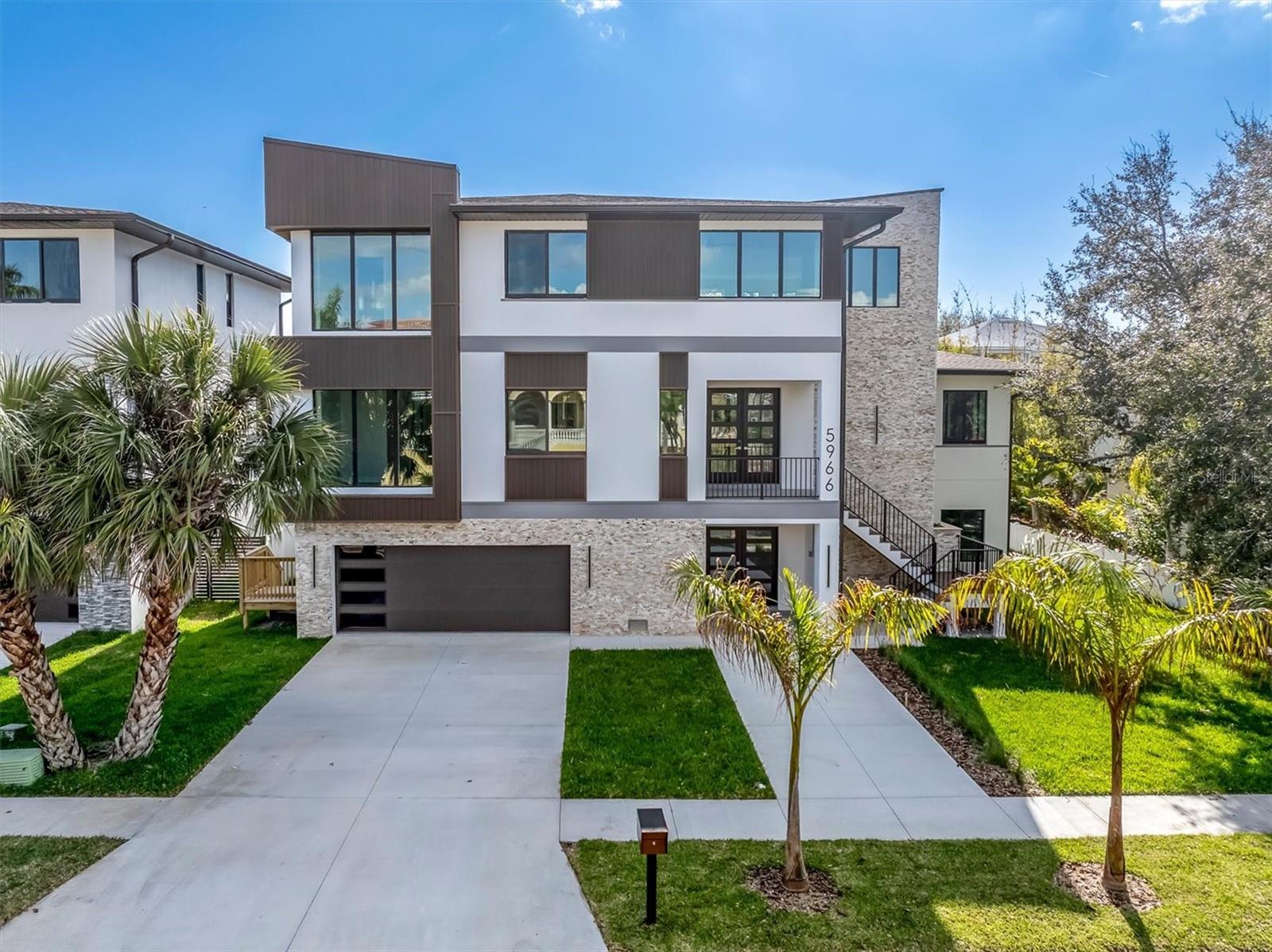 One or more photo(s) has been virtually staged. Experience modern coastal luxury in this newly constructed Pasadena Model Home, where striking contemporary architecture meets timeless Florida charm. Designed with clean lines and sunlit open spaces in cool gray tones, this residence blends style and function with effortless grace. Set within the exclusive gated Pasadena Yacht & Country Club community, this Skimmer Point masterpiece features a sparkling private pool and an impressive 4-car garage—perfect for those who value both elegance and practicality. Inside, sophisticated finishes, soaring ceilings, and seamless indoor-outdoor living spaces invite relaxation and entertaining alike. Residents have available the ability to join with a shorten wait time, the premier Pasadenta Yacht & CC with amenities including a private Arnold Palmer–designed golf course, full-service clubhouse, fine dining, tennis and pickleball courts, and an 80-slip marina accommodating yachts up to 80 feet. Just beyond the gates, discover the charm of downtown Gulfport—a short stroll away—offering boutique shopping, waterfront cafés, lively restaurants, and vibrant local markets. Including the luxury of Downtown St Petersburg, the beaches and Tampa, all of which just minutes away! This home is not just a residence—it’s a lifestyle defined by coastal sophistication and resort-style comfort.
