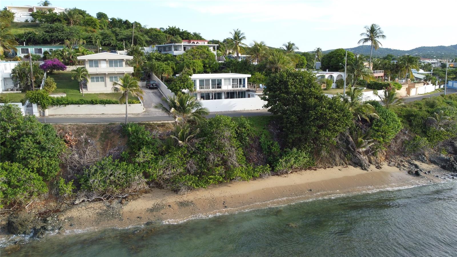 Discover Island Dreemz, a rare oceanfront duplex perched dramatically along the cliffs of Vieques' scenic North Shore. Located in the highly desirable Bravos de Boston neighborhood, this turnkey property offers breathtaking, unobstructed views of the Caribbean Sea and neighboring Culebra Island—an opportunity not often available in the Vieques real estate market.

Designed as a successful short-term rental with a loyal guest base, Island Dreemz features two distinct units—one on each floor—with a total of 4 bedrooms, 3 bathrooms, and 2 full kitchens. Both levels are designed to showcase the views, with walls of sliding glass doors that open to the sights and sounds of the sea. Whether for personal enjoyment or continued use as a rental income generator, this flexible layout offers exceptional value and versatility.

Upper Unit Highlights
The main floor opens into an airy living, dining, and kitchen area with natural stone tile floors and vibrant local artwork. The space extends seamlessly to a lush, landscaped backyard and a spacious 1,600-square-foot ocean-facing wood deck—ideal for dining, entertaining, and sunset watching. Two bedrooms, each with an en-suite bathroom, offer comfort and privacy. The primary suite also enjoys direct access to the deck, allowing the outdoors to become part of the everyday experience. A laundry room is conveniently located off the hallway.

Lower Unit Features
Accessed via a private courtyard, the lower unit includes an open-plan living/dining/kitchen area with sweeping views of the ocean. Two bedrooms and one shared full bath complete this level, offering guests a private and relaxing stay. Sliding doors lead to a patio perched above the shoreline—a perfect setting for morning coffee or evening cocktails.

Additional Features

Titled Property

Garage below the upper-level deck

Separate backyard casita for storage, gardening, or creative use

Lush tropical landscaping with mature trees and flowering plants

Close to the Punta Mulas lighthouse, Vieques ferry terminal and surfers beach.

This property combines form and function with an unbeatable location—just minutes from town, beaches, and local dining. The blufftop setting not only enhances the views but also protects the home from direct salt spray while maintaining close proximity to the waterline for that immersive coastal experience.

Whether you're looking to generate consistent rental income or simply enjoy a slice of paradise for yourself, Island Dreemz represents a rare offering in the Vieques market. Oceanfront homes of this caliber, with turn-key readiness and proven income history, are few and far between.
