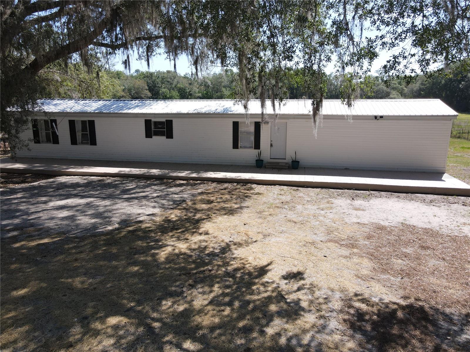 Set on 1.25 beautiful acres in a peaceful country setting, this inviting 3-bedroom, 2-bath home offers the perfect blend of comfort and functionality. Inside, you’ll find luxury vinyl plank flooring, textured walls, ample storage, a versatile flex room, and a thoughtfully updated kitchen featuring beautiful concrete countertops and newer appliances. Important improvements, including a 2020 roof, 2020 HVAC, and 2023 hot water heater, add lasting value and peace of mind.

Step outside to enjoy the serene surroundings from the massive concrete front porch or the lovely back deck overlooking the property. Fencing across the front with a lockable gate provides privacy and controlled access, while spray insulation beneath the home’s skirting and a newer gravel driveway add to the property’s overall appeal. Conveniently located near Gainesville, Bronson, and Williston, this home offers low taxes, plenty of room to spread out, and the relaxed lifestyle so many buyers are seeking.