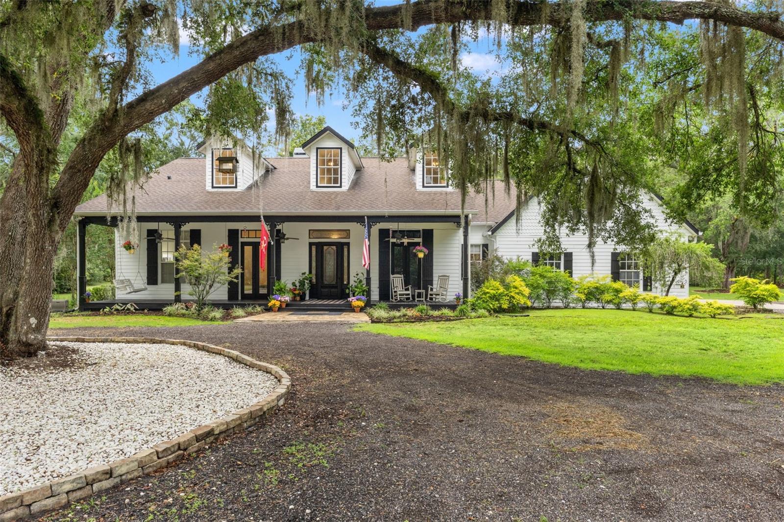 The world moves fast. Home should be your haven.
Beyond the gated entrance and at the end of a 1,500-foot tree-lined driveway sits a piece of Florida that's becoming increasingly difficult to find. Ten acres of fenced and cross-fenced land with improved pastures, mature grandfather oaks, exceptional landscaping, room to roam, and skies that still fill with stars at night. Located just east of US-41 and only five minutes from the Suncoast Parkway, you're just 35 minutes to Tampa International Airport, approximately 20 minutes to the Gulf of America and some of Florida's finest fishing and boating, and about an hour from Walt Disney World. This is Hernando County—where farms, horse properties, spring-fed rivers, and Old Florida still thrive.  The custom 3,450-square-foot farmhouse has been thoughtfully refreshed with a newly updated kitchen, fresh interior and exterior paint, wood beams, brick columns, and timeless finishes throughout. Offering 4 well-appointed bedrooms, an office, large bonus room, 3.5 baths, an oversized mudroom/laundry, exceptional storage, and a three-car garage, the home was designed for both everyday living and gathering with family and friends. Seven French doors open onto expansive porches and outdoor living spaces, creating a seamless connection between home and land.  Outside, the saltwater pool, covered back patio, brick-paver entertaining areas, and outdoor fireplace invite you to spend your evenings or mornings embracing the outdoors. The farm is ready to go with improved pastures, a two-stall barn, three paddocks, fencing and cross-fencing, a feed and tack room with water and electric, a gardening shed, well house, and a large, thoughtfully designed chicken coop. Whether your plans include horses, livestock, a thriving garden, or simply enjoying the quiet of country life, the infrastructure is already in place.Additional features include a 22kW whole-house Generac generator, private well with irrigation, and a 2017 roof.
If you've been searching for a place where life slows down without giving up convenience, welcome home!.
The current owners have ginuinely loved this property, continually investing in and caring for every aspect of the home and farm. Their decision to sell comes not from leaving a lifestyle and area they love, but from repositioning for new bi-coastal opportunities. It creates a rare chance for the next owner to enjoy a property that has been exceptionally cared for and is ready for its next chapter.
