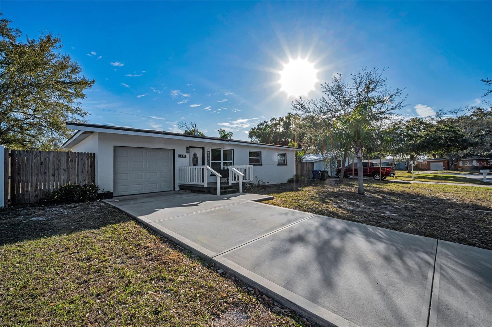 This cozy 3 bedroom/2 bath home is set well back from a quiet road but minutes from the vibrant, golf cart friendly Dunedin downtown! And yes, ability to get to downtown Dunedin by golf cart! With a cozy front porch and a fenced in yard there are a million memories to be made in this COMPLETELY RENOVATED (2023) residence with NO HOA fees! No HoA Lease Restrictions (buyer to verify minimum leasing period with county and city). Not a detail was overlooked in this transformation from the NEWER ROOF (2023) and NEWER impact windows to the newly poured driveway. A NEW A/C was installed in 2022. Inside, the open concept floor plan is filled with natural light illuminating the spacious living room as well as the welcoming formal dining room surrounded by windows with access to your outdoor space. Recessed lighting in the kitchen shines down on the exquisite cabinetry, a large center island with counter seating, lustrous tiled backsplash, sleek countertops, built-in pantry, tons of storage space, and stunning Samsung appliances. Easy care laminate flooring graces the airy bedrooms contrasted by freshly applied, neutral paint on the walls, new ceiling fans, and plenty of closet square footage. Both bathrooms were beautifully transformed with gorgeous tile and fine fixtures/finishes accompanied by modern stylings. The 2nd bathroom boasts a whirlpool tub. Even the laundry room is well appointed with space and storage. Nestled in what is affectionately known as “Delightful Dunedin” famous for its restaurants, markets, local celebrations, and gorgeous waterfront, this home is ideally located between Keene Road and Alternate 19 with Main Street/Route 580 running East and West. You’ll find the best of all worlds with proximity to everything while enjoying the peace and quiet of this wonderful enclave.