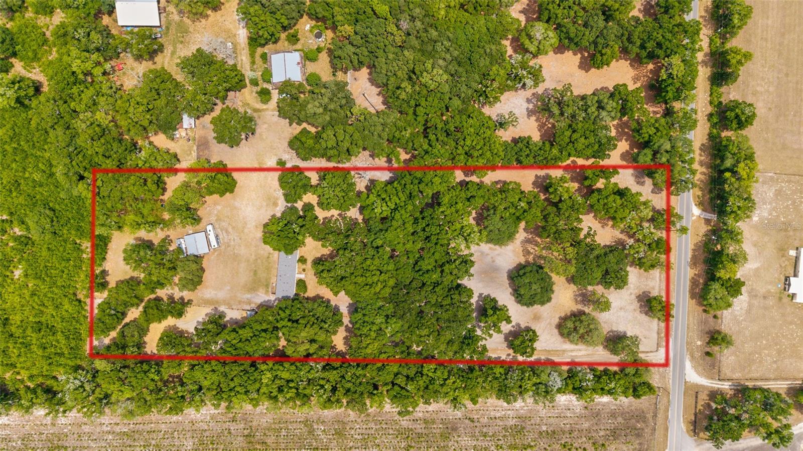 Welcome to this beautifully laid-out 6.50-acre property offering the perfect blend of functionality, comfort, and convenience—ideal for those looking to enjoy country living with room for animals and hobbies alike. Tucked behind an electric front gate and shaded by scattered granddaddy oaks, this property is thoughtfully designed and move-in ready.

The 4-bedroom, 3-bathroom home offers 2,052 square feet of living space with a large, open floor plan filled with natural light. At the heart of the home, the spacious kitchen features an abundance of cabinetry and countertop space—perfect for everyday living or entertaining. The living area is warm and inviting with a wood-burning fireplace, creating a cozy focal point. Recent updates add value and peace of mind, including a 2024 roof, updated guest bathroom, new kitchen backsplash, upgraded electric panel box, reinforced skirting, and a brand-new front deck that enhances both curb appeal and outdoor enjoyment.

Equestrian and livestock enthusiasts will appreciate the well-equipped exterior. The property is fully fenced with no-climb wire and includes four paddocks, three of which feature 10x10 run-in shelters for your animals. A round pen is already in place, making this a functional setup from day one. The large metal outbuilding adds incredible versatility, complete with electric, water, and A/C—ideal for a workshop, storage, or future customization to suit your needs.

Conveniently located, this property offers easy access to nearby towns and amenities while still maintaining a peaceful, rural setting. Located less than 7 miles to Williston, 15 miles to Dunnellon, approximately 30 miles to Gainesville, 35 miles to Crystal River for boating, and just 16 miles to the World Equestrian Center, with a short drive to HITS Showgrounds.

This is a fantastic opportunity to own a well-maintained, turnkey mini-farm in a prime Central Florida location.