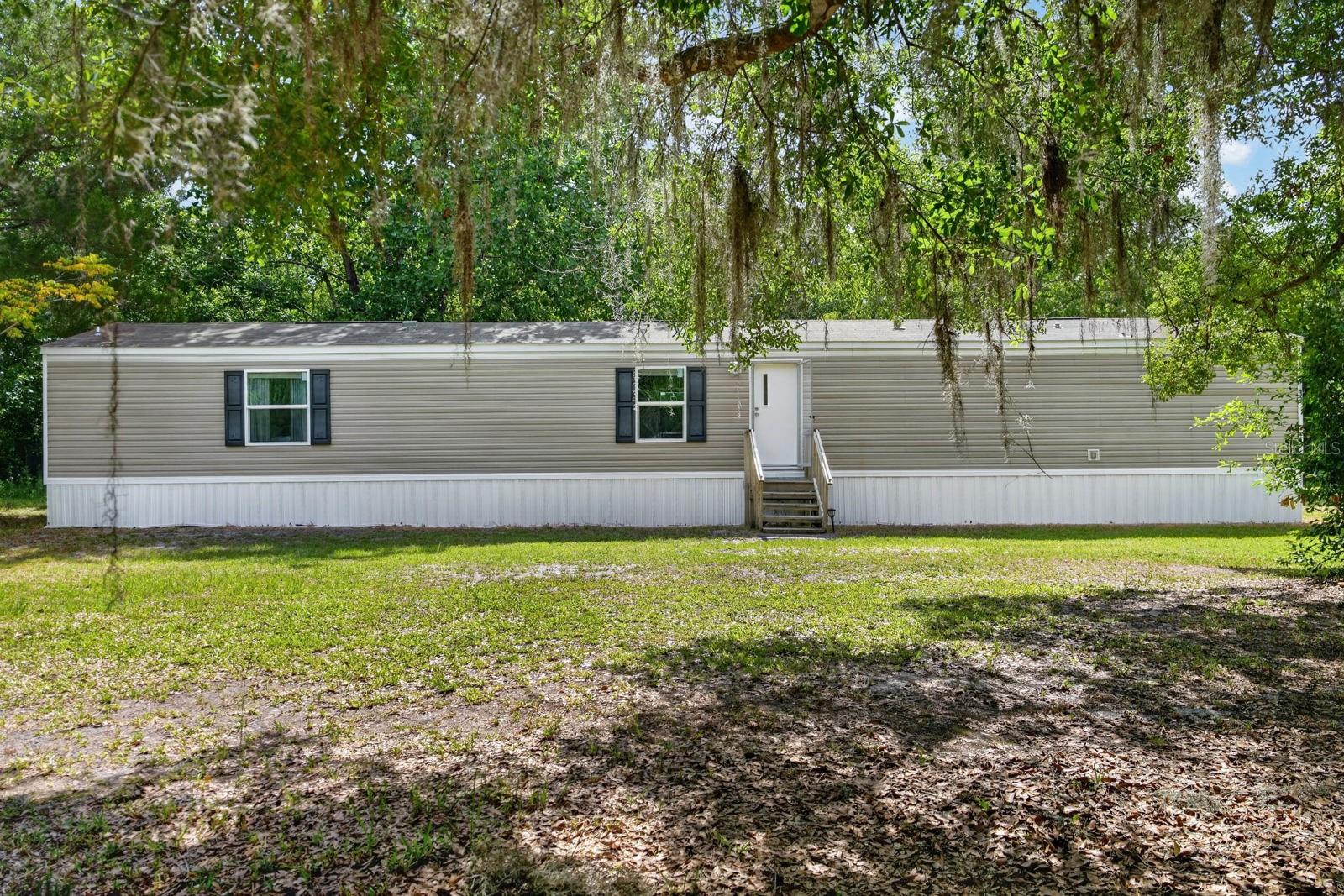 Welcome to your own private bucolic oasis! Located off a quiet country road on a beautiful lot with plenty of mature trees, this home is waiting for you to make it yours.
The tree-lined property includes a front gate and fence for added security/seclusion, with plenty of grassed area. Bring your boat, RV, and equipment as the exterior includes ample open space, a carport with concrete slab, as well as a large shed.
The nicely maintained home is a 2020 manufactured home that includes 3 good-sized bedrooms and 2 full baths. Additionally, inside this country charmer there's just under 1200 square feet of living space covered in beautiful and easy to maintain wood-like vinyl flooring throughout. The kitchen is open to the rest of the living area and includes countertop-seating and a cozy dining area with a great view of the beautiful backyard space.
The home's split floor plan design includes plenty of windows throughout to let in natural light to the bedrooms while offering the chance to gaze at the trees to spot birds and wildlife. The master bedroom includes a large bathroom with an attached closet as well as a large tub with separate shower. At the opposite side of the home, the interior laundry area includes a washer and dryer that are conveniently near the 2 secondary bedrooms, which each contain nice-sized closets. There are lots of great features, both inside and outside this home!
Come experience the beauty of this hidden gem, just a short drive west of the beaches, where you can sit back and enjoy a true rural lifestyle with modern conveniences nearby!
