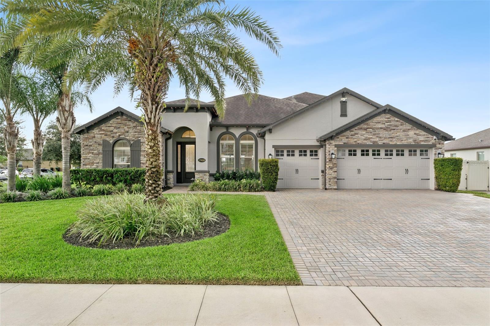 Refined elegance awaits in this luxury home in The Estates at Lake Pickett. A bright, open entry showcases the architectural sophistication found throughout much of the home. The plantation shutters and oversized 12x24 tile found across the entire first floor. The great room and kitchen create an open and inviting area built for entertainment and is comprised of luxury fixtures and finishes.  The primary suite continues more details, tray ceiling, layered crown molding.  The ensuite bath with a soaking tub and tile inlays in the spa-like bath. Bedrooms 2, 3, and 4 all feature crown molding — 2 and 3 share a Jack and Jill bath, while 4 has its own that doubles as the pool bath.  Upstairs, a 20x24 media/bonus room with crown molding and built-in storage, plus an additional storage closet and 5th bedroom with full bath — perfect for guests or multigenerational living.  Walk out through the enclosed lanai to large and beautiful luxury pool and entertainment complex, complete with two pergolas — one for conversations, the other housing a bar, outdoor kitchen, and covered gathering space. The expansive 50x40 paver pool deck is framed by privacy landscaping, with an astroturf play and games area. A 3-car garage completes this exceptional home.  The community has private access to Lake Pickett, known for its array of water sport activities.  There is so much more, must be seen to be appreciated!  Call for your private showing.