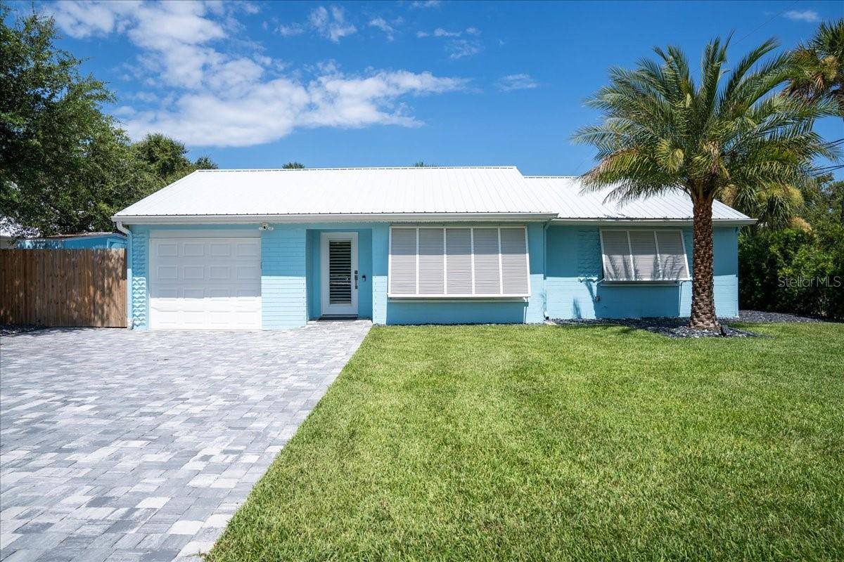 Under contract-accepting backup offers. Stunning, fully renovated beach house ready to be yours! This light and bright 3-bedroom, 2-bath home offers a flexible floor plan, with the third bedroom currently being used as a dining room, making it ideal as a home office, den, guest room, or formal dining space. Tucked away on a quiet street just off the beaten path, you'll enjoy the perfect balance of privacy and convenience with just a 5-minute walk to the beach and a 3-minute walk to the restaurants, shopping, and entertainment of Flagler Avenue. This exceptional home has been extensively updated in 2025 with a metal roof, natural gas tankless water heater, electric pool heater, water softener, pool filter cartridge housing, pool chlorinator, pool cage screen, paver driveway and backyard patio, irrigation system for the front and back yards, fresh sod and tropical landscaping, and fresh interior and exterior paint. The renovations continue with a beautifully remodeled kitchen featuring stunning blue-veined quartz countertops, soft-close cabinetry, Viking appliances including a natural gas cook-top, and a built-in ice maker. Additional 2025 improvements include a completely remodeled second bathroom, custom interior doors, Bahama plantation shutters throughout, crown molding, 6-inch baseboards, Samsung washer and natural gas dryer, and luxury vinyl plank flooring throughout. Step into your own tropical backyard oasis, thoughtfully designed for outdoor living and entertaining with ambient lighting, colorful shade sails, a built-in natural gas grill, refrigerator, sparkling pool, and lush mature landscaping. Situated on a rare double lot, this move-in-ready coastal retreat offers modern luxury, exceptional outdoor living, and an unbeatable location just moments from the beach and everything New Smyrna Beach has to offer.