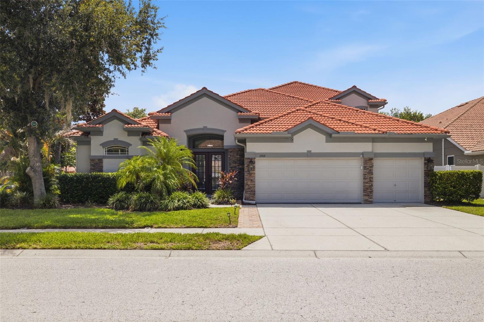 Welcome to 11508 Oyster Bay Circle in the prestigious gated community of Waters Edge in New Port Richey, FL—an exceptional 5-bedroom (2 primary suite - 1 on the main level) + office + bonus room, 4-bath pool home with a 3-car garage offering over 3,600 square feet of beautifully updated living space. Perfect for multigenerational living! Situated on a desirable corner lot, this impressive Barrington model seamlessly blends luxury, functionality, and resort-style living. Designed with entertaining in mind, this home features an open-concept floor plan with soaring ceilings, abundant natural light, and multiple sets of sliding glass doors that open to the private outdoor oasis. The screened paver lanai showcases a newly resurfcaed heated swimming pool, new pool pump, all overlooking a fully fenced backyard perfect for year-round Florida living. The heart of the home is the fully remodeled gourmet kitchen, featuring quartz countertops, a striking quartz backsplash, premium wood cabinetry with updated hardware, professionally refinished cabinets, stainless steel appliances, a center island, breakfast bar with designer pendant lighting, and a spacious walk-in pantry with custom shelving. Beautiful new Luxury Vinyl Plank (LVP) flooring delivering the warmth and elegance of hardwood with the durability and easy maintenance today's buyers love. The luxurious first-floor primary suite offers tray ceilings, dual walk-in closets, and a beautifully renovated spa-inspired bath complete with dual quartz vanities, soaking tub, custom tiled walk-in shower and glass enclosure, shiplap accent wall, and private water closet with easy access to the pool. A separate guest suite with adjacent full bath, dedicated home office with French doors, formal dining room, breakfast nook, family room with dramatic stacked stone feature wall, laundry room, and spacious living areas complete the first level. Upstairs, you'll find a versatile bonus room, a second private primary suite with renovated en-suite bath, two additional oversized bedrooms, another full bathroom, and abundant storage. Additional upgrades include a new water heater, new water softener, EV charging station, generator hookup, crown molding throughout the first level, chair rail detailing in the office, 4-inch baseboards, landscape lighting, tile roof, stacked stone exterior accents, tropical landscaping, and an expansive driveway. Residents of Waters Edge enjoy an outstanding amenity package including a resort-style clubhouse, community pool, splash pad, fitness center, basketball and pickleball courts, fishing pier, reclaimed irrigation, cable, high-speed internet, trash and recycling service, and gated security—all included in the HOA. Ideally located near shopping, dining, medical facilities, top-rated schools, parks, golf courses, and convenient access to the Suncoast Parkway, this exceptional home offers the perfect combination of luxury, comfort, and convenience. Experience Florida living at its finest—schedule your private showing today!