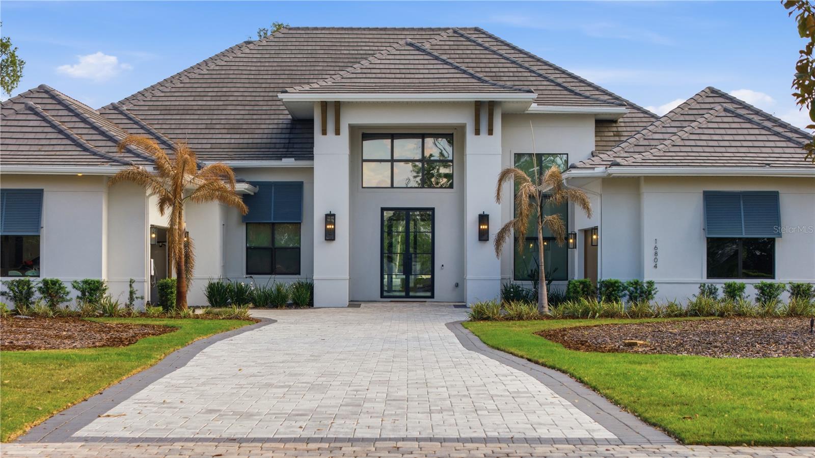 Welcome to luxury living in the prestigious gated community of Bella Collina. This stunning custom residence blends modern elegance with warm, timeless finishes, offering a lifestyle designed for both refined comfort and unforgettable entertaining.

From the moment you step through the oversized glass entry doors, you’re greeted by soaring ceilings, natural light, and a sense of calm sophistication that instantly feels like home. Every space has been thoughtfully designed to create an effortless flow between indoor and outdoor living.

At the heart of the home is a show-stopping chef’s kitchen with dual oversized islands, premium appliances, and custom cabinetry—perfect for hosting gatherings, celebrating milestones, or simply enjoying everyday moments with family and friends. The open-concept living and dining areas are enhanced by designer lighting, wood beam accents, and expansive sliding glass doors that invite the outdoors in.

Step outside to your own private resort-style backyard, where every day feels like a getaway. The expansive custom-designed lap pool with sun shelf and water features is surrounded by multiple lounging areas, a pergola, fire pit, and generous green space—creating the perfect setting for sunset evenings, weekend gatherings, or quiet mornings with coffee in total privacy.

Adding to the home’s flexibility is a detached casita with a full bathroom, ideal for hosting guests in comfort, creating a private home gym, a serene office, or a stylish mother-in-law suite—offering both independence and connection.

Inside, the bedrooms and bathrooms provide a peaceful retreat with clean, modern finishes and abundant natural light, designed to recharge and relax after a long day.

This home is ideal for the buyer who values space, privacy, design, and lifestyle—someone who loves to entertain, appreciates thoughtful details, and wants a home that feels both luxurious and welcoming.

Located in Bella Collina, residents enjoy world-class amenities including a championship golf course, spa, fitness center, fine dining, and the unique beauty of Central Florida’s rolling hills—just a short drive from Orlando.

This is more than a home—it’s a place where memories are made, where mornings feel peaceful, and evenings feel extraordinary.