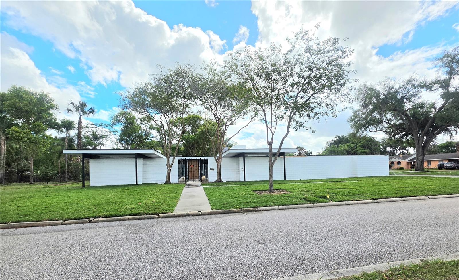 This home is amazing. The famous Winter Haven Architect, Gene Leedy, built this home in 1959. (Background on the architect: he was the pioneer of the modern movement in Florida and the founder of The Sarasota School of Architecture. He received over 50 awards both nationally and state wide, including the lifetime design achievement award.)  It has so many features that have recently been updated. The pictures do not do this home justice, it must been seen to be appreciated.  The architecture of the building alone is definitely a show stopper. Several of the outstanding features of this home include floor to ceiling window, transom windows, electromagnetic non-steam mirrors as well as a 3 valve shower in the luxury primary bath, an electric in wall fireplace, canned recessed lights, marble countertops throughout, several skylights, laundry room, new windows, new sod and irrigation system, beautiful iron gated courtyards front and rear, a new outdoor summer kitchen with a half bath, and a Pergola between the summer kitchen and the house. If you like a spacious lot this one sits on a corner with 3 lots giving lots of room to put additional detached garage, a pool, etc. All the appliances are new Samsung with a built in wine cooler and coffee maker also. Another great feature is this home has stayed with the original owners and the current owner grew up in this home. Walking distance to a large neighborhood park. If you love modern architecture then this home is waiting for you!
